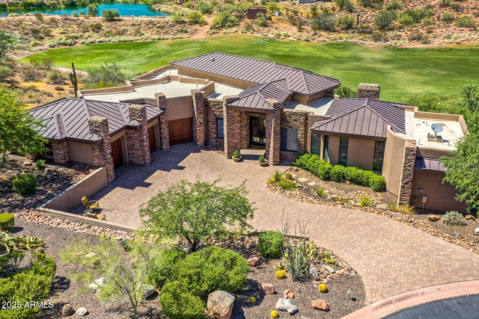 Indulge in refined elegance with this masterfully crafted residence, ideally set along the 7th fairway of the prestigious FireRock Country Club. Perfectly positioned with desirable North-South exposure, this exceptional home seamlessly blends luxury, comfort, and breathtaking views, creating an idyllic retreat for the discerning homeowner. 
Step inside to an expansive open-concept floor-plan designed for both grand entertaining and everyday single level living. The chef's kitchen is a culinary masterpiece, outfitted with top-tier Viking and Bosch appliances, including a gas cooktop, double ovens, and custom staggered cabinetry. A walk-in pantry provides ample storage, while the center island invites casual gatherings. The adjacent living area, complete with a thoughtful fireplace, offers complete with a thoughtful fireplace, offers stunning vistas of the lush fairways and surrounding mountains.

The primary suite is thoughtfully secluded on the main level, providing a private sanctuary with serene views and spa-like comforts. Two additional guest bedrooms, a versatile den, and a convenient laundry room complete this floor, ensuring both functionality and ease of living.

Descend the elegant staircase to a fully finished lower level, where entertainment opportunities abound. This level features a second primary suite, a guest bedroom, and an inviting family room. The space is further enhanced by a custom wet bar, an impressive wine room, an intimate theater, and a spacious game roomperfect for hosting unforgettable gatherings.

Outside, your personal resort awaits. The beautifully designed backyard oasis boasts a large covered patio, a sleek modern pool and spa, a built-in gas grill, and a cozy gas fire pit. The travertine patio adds a sophisticated touch, while the backdrop of Arizona's iconic sunsets paints a picture-perfect setting for relaxation or entertaining.

This is more than a homeit's a lifestyle, offering luxury living in one of the most sought-after private golf communities. Experience the very best of FireRockwhere elegance meets ease.