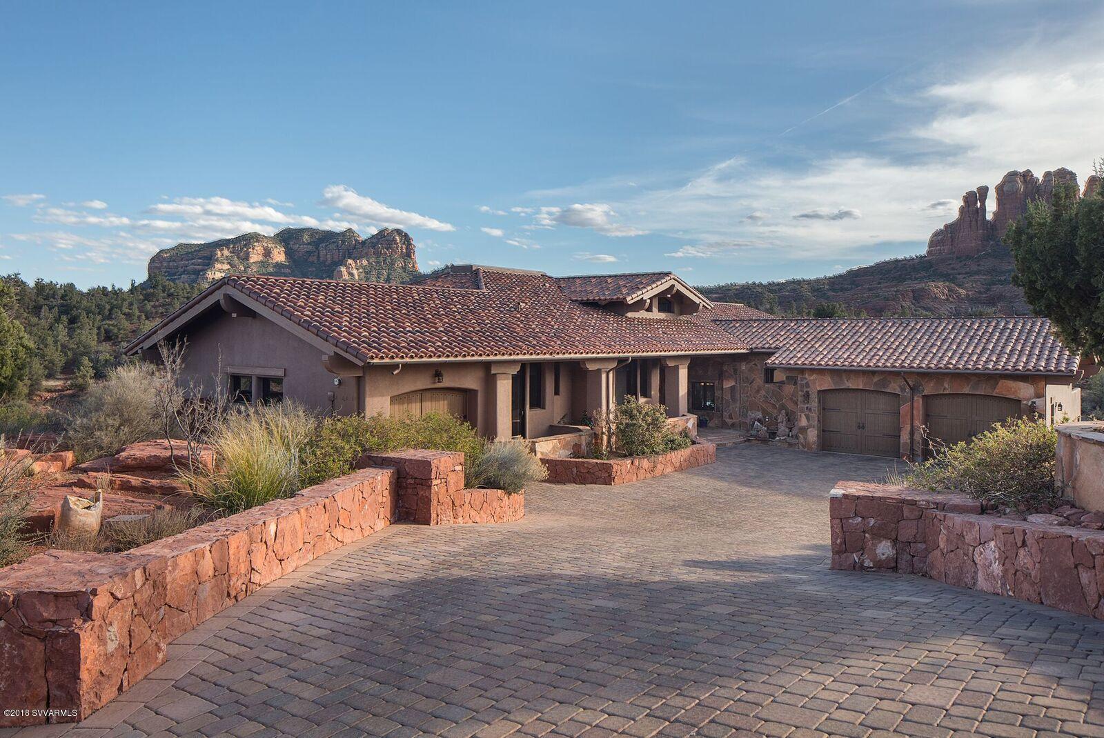 MASSIVE Red rock views! Stacked mission tile roof, heated travertine floors, solid teak doors, soaring beamed ceilings with  huge windows allowing the views inside.  Centrally located, gated community on 1.65 acre. Garage space for nine vehicles.  Great room with fireplace, gourmet kitchen with granite counters, custom cabinetry, huge walk in pantry, wolf and sub-zero appliances, center island with eating bar. Den/library with fireplace. Wonderful master bedroom with 3rd fireplace, two large walk-in closets, spacious bath, his/hers sinks and toilet rooms, jetted tub, large separate shower. Two additional suites &  baths,family game room , separate inlaw suite, large terrace with disappearing edge pool, spa, cabana with views of Cathedral rock.  Dale Aspevig, architect. SEE PHOTOS & VIDEO