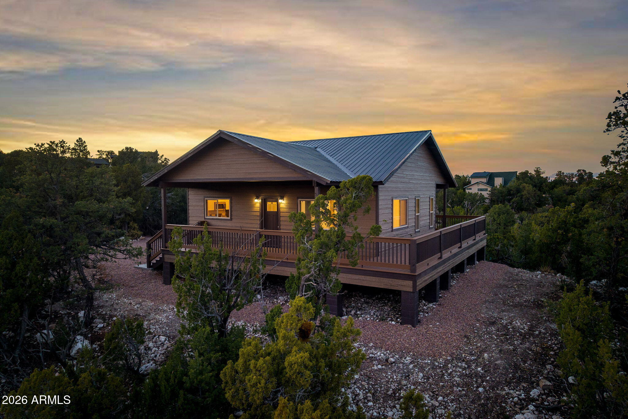Brand-new 2026 build with a wrap-around deck in High Country Pines.
Trade 110-degree Phoenix summers for 70-degree afternoons on the deck. At 6,600 feet in Heber-Overgaard, this brand-new 2026 cabin sits on 0.73 acres that borders an HOA-owned greenbelt between neighbors. Not a buildable parcel, so the trees and privacy behind you stay that way. 

Apache-Sitgreaves National Forest is just minutes away for hiking, hunting, ATV trails, and fishing.

The wrap-around Trex deck is where you'll spend your time, looking out over the pine, pinyon, and juniper forest that's your backyard.

Inside, 832 sq ft with a surprising sense of space: vaulted ceilings throughout, and windows that frame trees and sky from every room. The U-shaped kitchen has granite counters, a deep single-basin sink, and white shaker cabinets. Full-size stackable washer and dryer tucked into their own closet off the great room.
Construction & warranties:

2x6 framed construction with foam insulation
30-year metal roof
30-year smart siding
25-year Trex wrap-around decking
Tankless hot water heater
Central heat & AC on a WiFi smart thermostat
20-month builder workmanship warranty, plus transferable manufacturer warranties on the roof, siding, decking, flooring, and HVAC

High Country Pines is an established Heber-Overgaard neighborhood with paved private-maintained roads, a low $60/year HOA, and more wildlife than traffic.

Whether you're looking for a full-time mountain home, a Valley-heat escape, or a low-maintenance weekend cabin, this one is move-in ready the day you close.