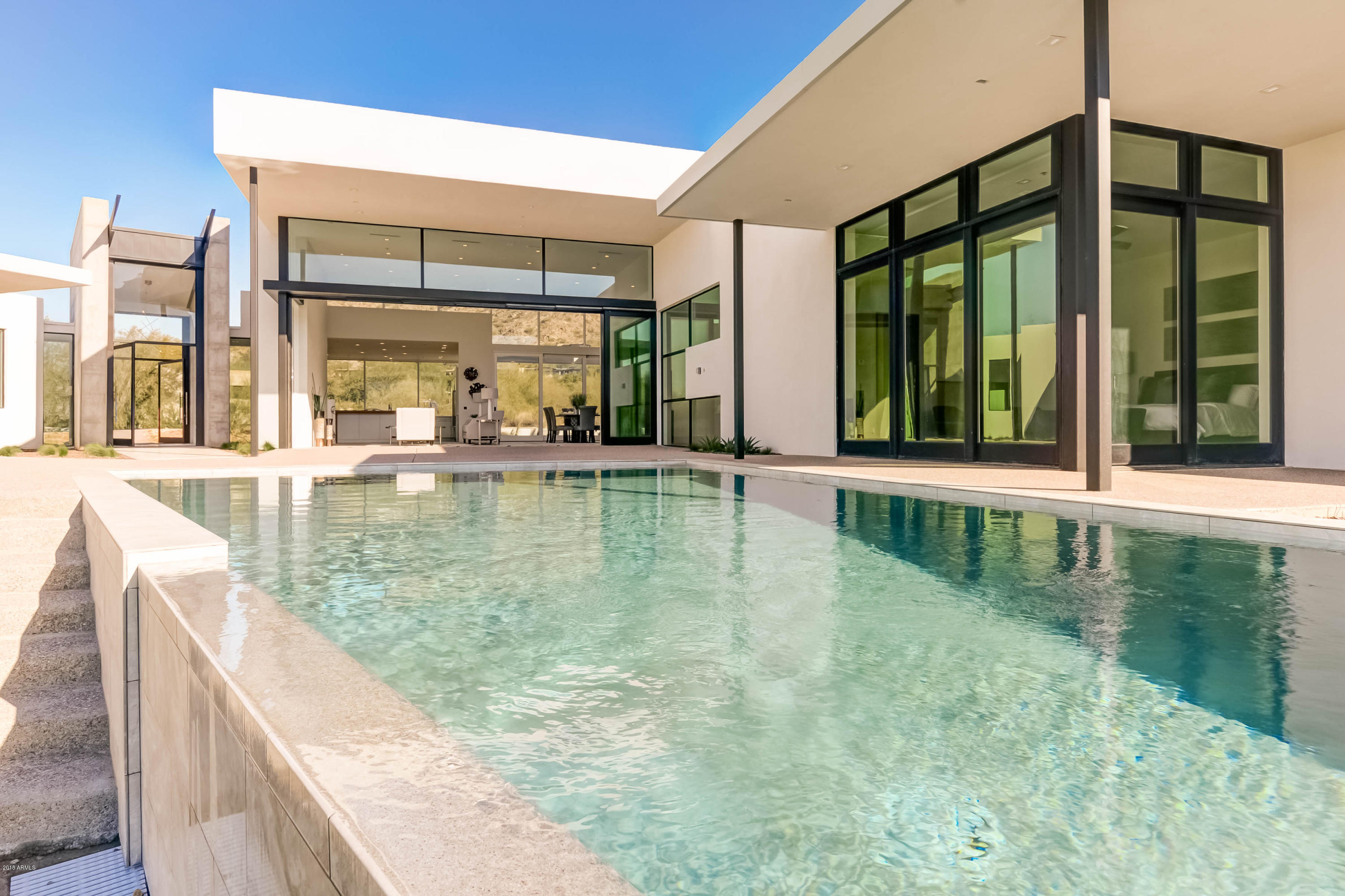 Clean lines, sophisticated style and uncompromised quality; this brand new, ground up residence has set the new level of excellence for all to compare against. Incredible design and details in each and every space of this; 3 bedroom plus office on the main level with gym/secondary office on the second (separate entrance)level. Constructed with insulated concrete form for an R51 energy efficient home. Neutral tones grace all of the open spaces and the sweeping mountains that surround the home and can be viewed from each and every room. Situated on over an acre of land in the PVCC neighborhood and set on the corner of the highly coveted Desert Fairways and Mummy Mountain Rd. This home is SINGLE LEVEL except for the 2nd office/gym, which is upstairs boosting 350sqft view deck.