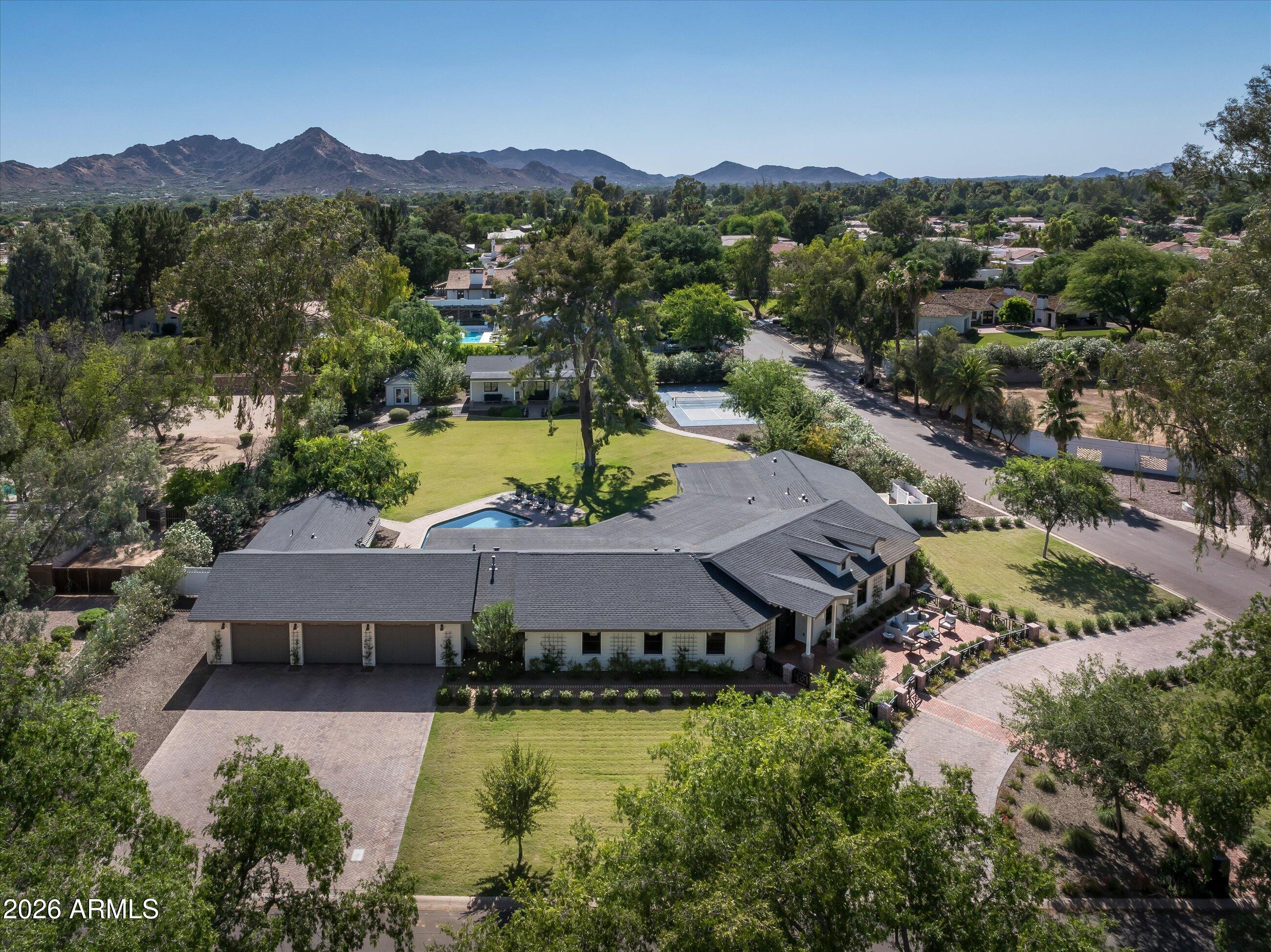 A rare opportunity to own one of Paradise Valley Farms' most complete lifestyle properties--where luxury living, recreation, and guest accommodations come together on a private 1+ acre corner lot. The property is designed for the way today's buyers want to live, entertain, and host.
The 4,000+ -square-foot main residence features four en-suite bedrooms, a dedicated office with custom built-ins, walk-in closet and adjacent to a full bathroom; Office could be used as the 5th ensuite bedroom in the main house. The great room, kitchen and dining rooms have 16'+ vaulted ceilings, wide-plank hardwood flooring, and wall of glass that creates a seamless connection to the outdoor living spaces. The open-concept floor plan is filled with natural light and anchored by a beautifully appointed kitchen featuring custom cabinetry, premium finishes, and generous gathering spaces.

Beyond the main home, a fully detached guest house provides exceptional flexibility for extended family, visitors, multigenerational living, or a private retreat. Together, the property comfortably accommodates large gatherings while maintaining privacy and comfort.

The backyard delivers the lifestyle buyers are actively seeking, with a full pickleball and sport court, expansive covered patios, manicured grounds, and multiple spaces for dining, entertaining, and relaxation. A versatile bonus room adjacent to the three-car garage is currently configured as a private fitness studio, complete with glass doors opening directly to the backyard, creating an ideal indoor-outdoor wellness space.

Few properties offer this level of functionality, privacy, and recreation on a full acre in one of Scottsdale's most desirable neighborhoods.

With no HOA, the sky is the limit for someone who wants to expand the footprint to make it fit their needs.