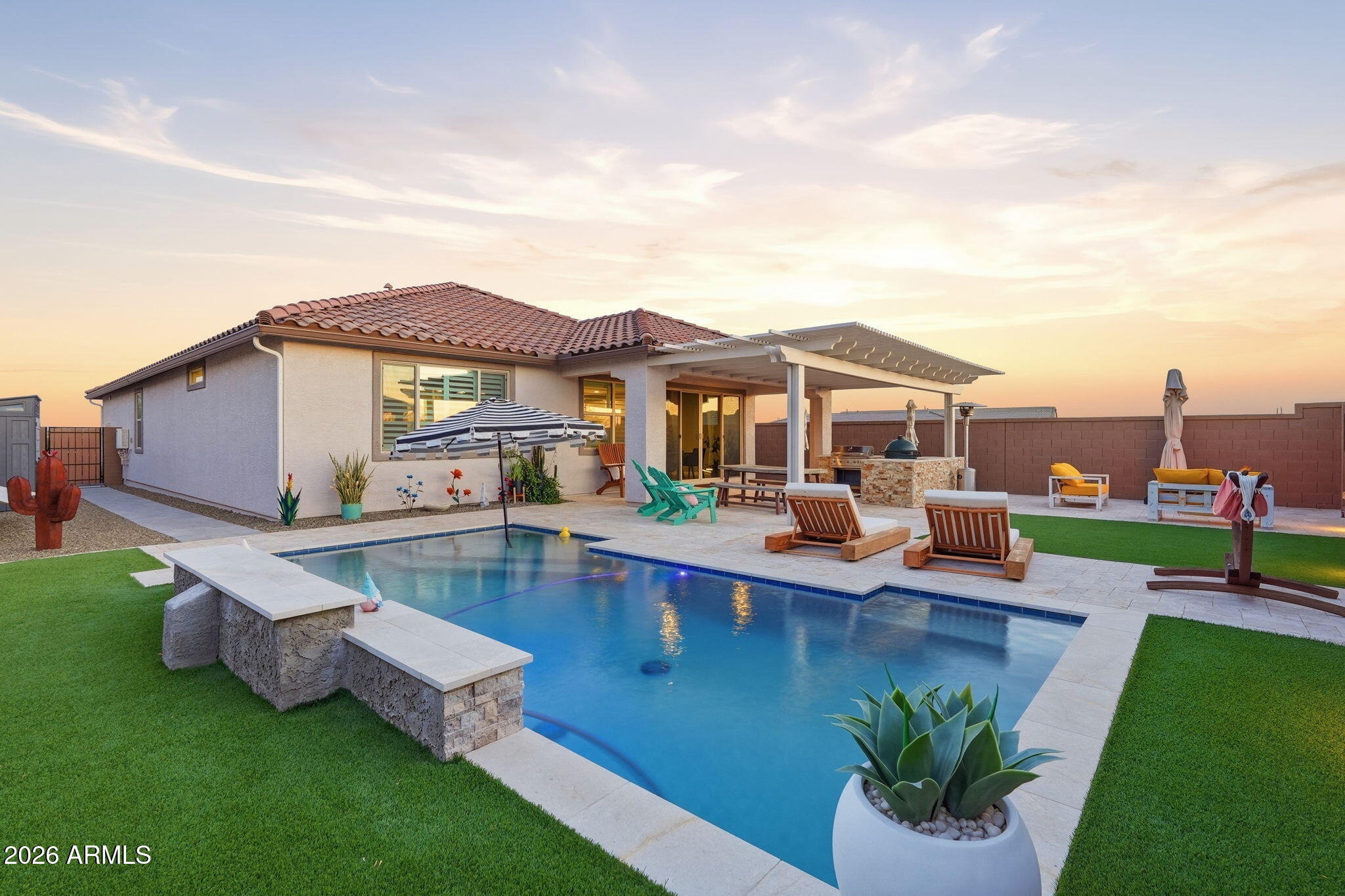 Welcome to your dream home and backyard paradise -- where luxury, comfort, & outdoor living come together in spectacular fashion! This stunning home is perfectly positioned on a quiet street next to a serene greenbelt, offering added privacy, peaceful surroundings, & beautiful MOUNTAIN VIEWS. Your private RESORT-Like backyard is truly an entertainer's dream, featuring a SPARKLING POOL with a cascading waterfall, expansive TRAVERTINE-tiled covered patio, cozy fire pit, & an incredible OUTDOOR KITCHEN complete with built-in gas cooktop & gas grill. Whether hosting unforgettable gatherings or enjoying a quiet Arizona evening under the stars, this backyard oasis delivers the ultimate lifestyle experience. Inside, the home impresses from the moment you walk through the door with designer plank tile flooring THROUGHOUT the Home-no carpet! Tall 9-foot ceilings, dramatic 8-foot doors, custom plantation shutters, and stylish accent paint throughout. The OPEN-CONCEPT floorplan is bright, spacious, and thoughtfully designed for both everyday living and entertaining.
The chef-inspired kitchen is the heart of the home, showcasing GORGEOUS 3 cm GRANITE countertops, an OVERSIZED ISLAND, subway tile backsplash, natural gas cooking, and abundant cabinetry -- blending beauty and function perfectly.
Retreat to the luxurious owner's suite, your own private sanctuary featuring a spa-inspired walk-in shower with CUSTOM TILE surround extending to the ceiling, dual GRANITE VANITIES, designer mirrors, and a spacious walk-in closet. Guests and family will appreciate the 3rd Bath along with the 4th Bedroom, creating ideal accommodations for visitors or multigenerational living.
Need flexibility? The BONUS ROOM/DEN offers endless possibilities as a home office, media room, fitness space, craft room, or playroom. Plus, INTERIOR WALL INSULATION provides exceptional peace and privacy throughout the home -- a rare and valuable upgrade.
Located in newer Peralta Canyon community, residents enjoy access to scenic walking trails, parks, pickleball courts, ramadas, and endless outdoor recreation surrounded by beautiful desert landscapes. This home is more than just a place to live -- it's a lifestyle designed for relaxation, entertaining, and making unforgettable memories.