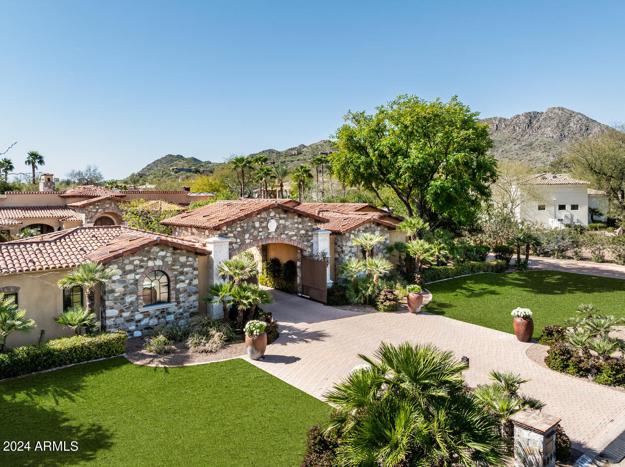 This home has a beautiful presentation! It is an absolutely gorgeous walled gated estate.  Enter thru a dramatic stone archway into an elegant courtyard with a large circular paver drive to the main residence which is not visible from the street.  The 6 bedrm estate includes a full guest house w/ kitchen, bedrm + bathrm. The main home has beautiful architectural detail and oak wood floors,  as well as a master with separate sitting rm and expensive mahogany + glass woman's closet, a paneled library, theater + walk in wine rm. The extraordinary backyard has extensive lawns + features an  award winning swimming pool with 4 firepits,  spillways + waterfalls cascading from real boulders.The gourmet kitchen with 2 pantries opens to the inviting family room which opens to the large theatre.