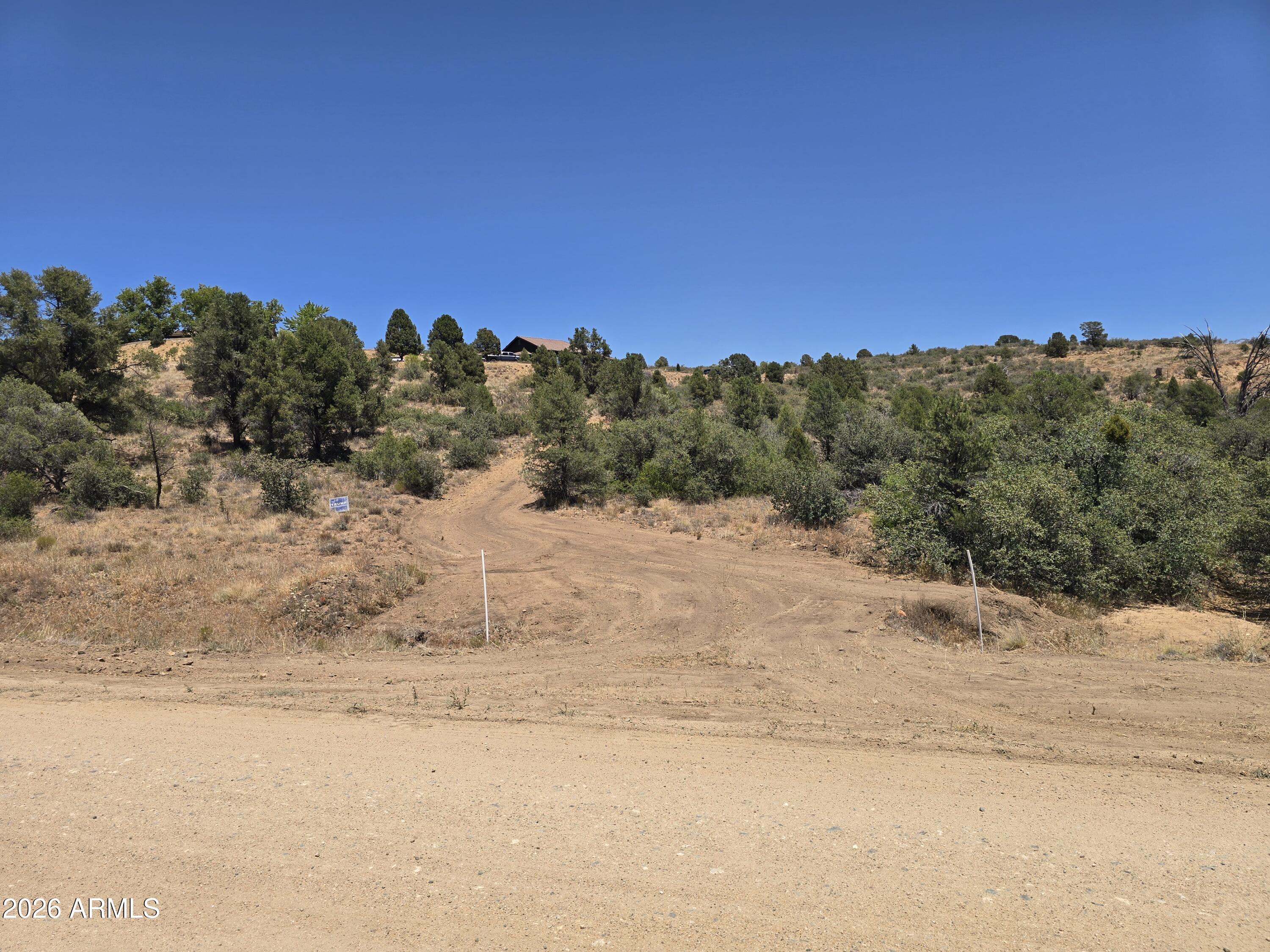 Incredible view lot with 2.36 acres in the highly desirable Pinon Estates of Peeples Valley--ready for your dream custom home! Sitting at an ideal elevation of approximately 4,500 feet, this premium parcel offers a cooler, comfortable climate with mild seasons, clear blue skies, and unmatched, panoramic mountain views in every direction. The hard work has already been started for you: a driveway is cut in and leads directly to a roughed-in building pad/established homesite. Electric and water are available at the property, and the lot allows for a minimum 1,500 sq. ft. site-built home with no HOA. Horses are welcome on this beautiful piece of land, where natural vegetation abounds and options are endless. Enjoy the peaceful, quiet country lifestyle Peeples Valley is famous for, alongside abundant hiking, walking, and wildlife watching right outside your door. Access is a breeze with county-maintained, paved roads leading all the way until just one block off Tawny Lane. Located just a few miles from Highway 89, this property provides the perfect balance of rural tranquility and modern convenience with an easy commute to Wickenburg, Prescott, and Phoenix. Don't miss this hidden gem! BE SURE TO VIEW VIDEO LINKS FOR VIEWS AND DRIVEWAY/SITE BUILD AREAS!