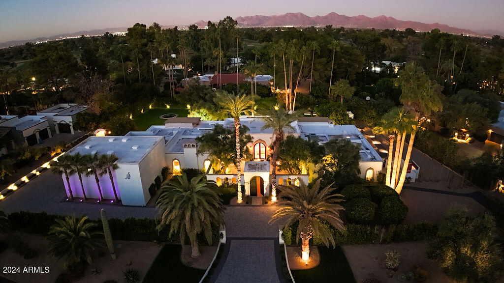 Discover the epitome of luxury one-level living in this stunning Paradise Valley estate, gracefully set on over an acre of private grounds. Designed with elegance and functionality in mind, this exquisite home offers soaring, sky-high ceilings and expansive accordion glass doors, seamlessly blending the indoor and outdoor living spaces. For car enthusiasts and adventurers alike, the estate includes an oversized RV garage with an additional 6 car spaces, an electric vehicle charger, and even a backup generator for added peace of mind.
Step into the heart of the home, where a custom stovetop and range complement the spacious, state-of-the-art kitchen, surrounded by storage galore and beautiful hardwood flooring. The estate boasts multiple fireplaces and is enhanced by imported Italian lemon trees, filling the air with fresh, Mediterranean aromas. Embrace year-round outdoor living with features like a private heated pool, in-ground trampoline, and mounted outdoor TVs, all enveloped by lush landscaping. Views of the stunning Mummy Mountain and located minutes from Camelback Country Club which features award-winning golf.
With extremely low HOA dues that even cover garbage collection, this estate is not only luxurious but practical.
