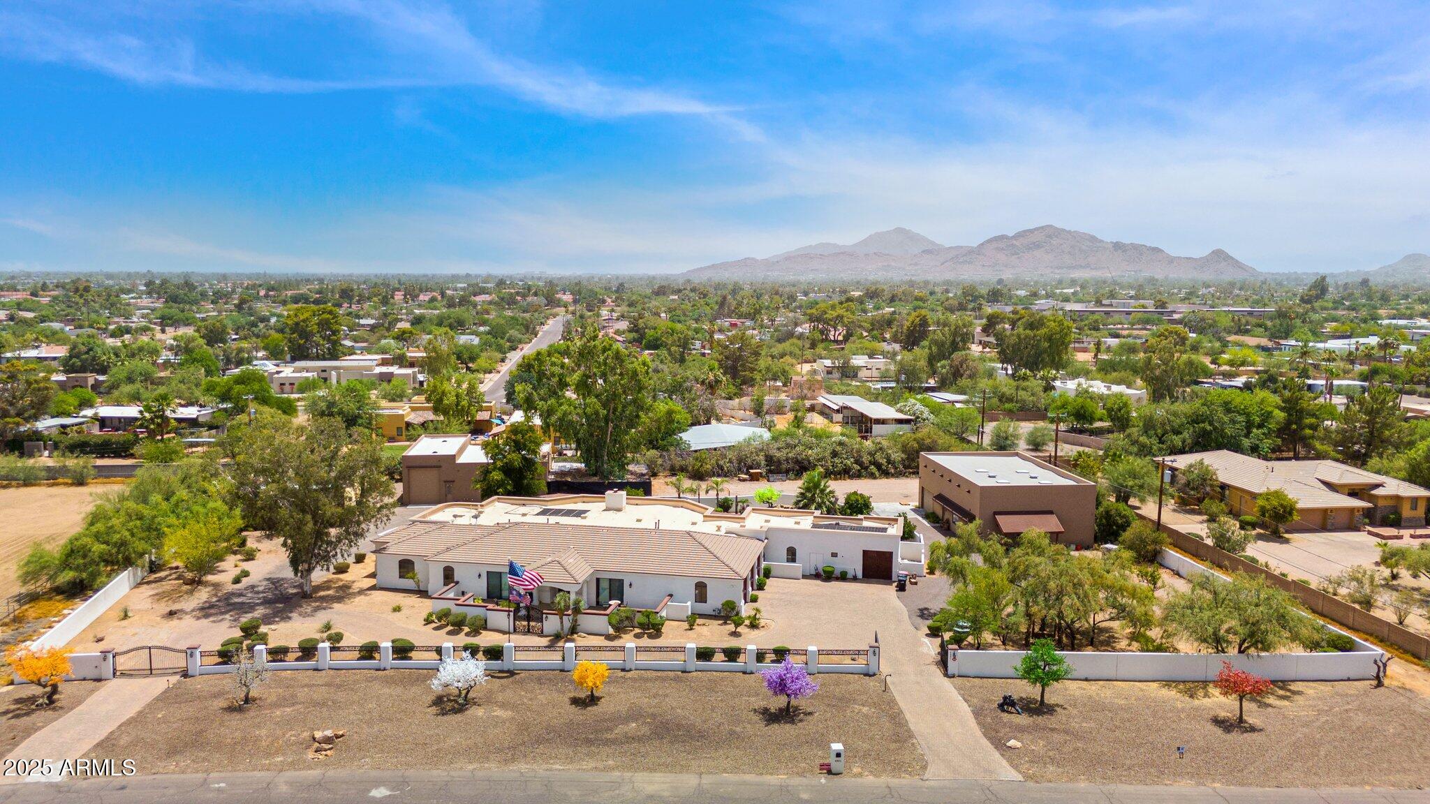 Arguably the best lot in Cactus Corridor. 2.2 Acres North/South exposure on Paradise Dr. Zoned R35 for a splittable parcel if desired or build the best estate seen in the Cactus corridor out of what is already on property.  This property boasts almost 6000 ft of living space between primary and guest home with sprawling under roof pool patios for tons of outdoor living. Car collector/ horse enthusiast/business owner this property has over 8000 additional feet of AC'd garage space with full RV garage, gym, storage and bathroom. With 2.2 acres there is still space for full horse setup, gardens or whatever your needs may be.  4 car garage in main home with up to 20+ if buildings are utilized. This property you must walk in person to see the value. Over 3MM in land value alone. 1MM+ in AC'd Buildings plus an existing 5500 Square foot custom home with detached guest casita.  This is a rare find and even more rare being right on the best section of Paradise Dr.
