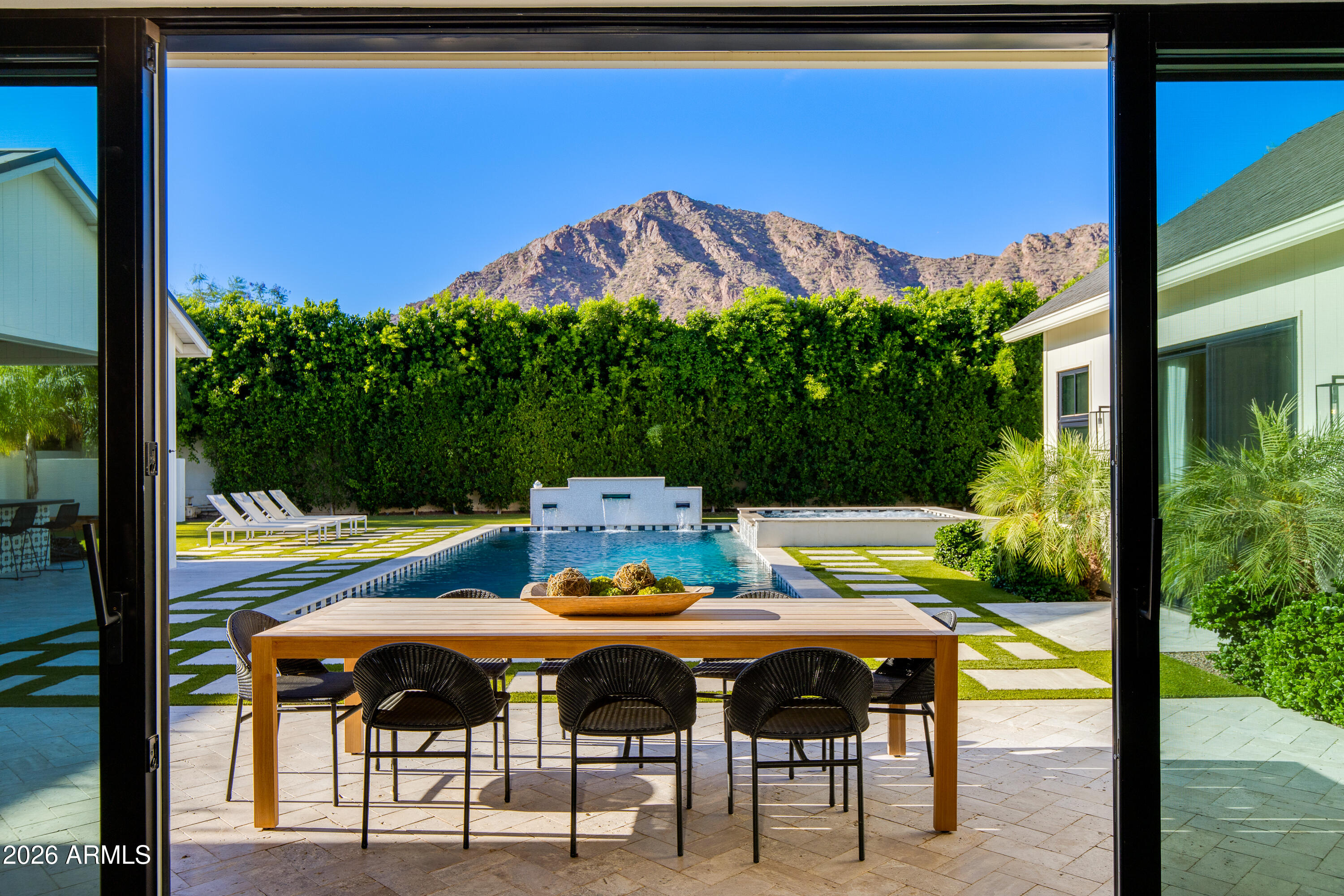 Situated within a prime cul-de-sac in the heart of Arcadia Proper, this extraordinary estate blends timeless luxury with exceptional design, all framed by lush mature landscaping and breathtaking Camelback Mountain views. Built in 2021, the single-level, open concept floor plan offers 5 bedrooms, 4.5 baths, and 5,800+ square feet of refined living space designed for both elevated entertaining and everyday comfort.  At the center of the home, the kitchen is beautifully appointed with premium appliances, an oversized island, custom cabinetry, gas cooking, and full back pantry. Multiple living and entertaining spaces flow effortlessly throughout the home, while the split floor plan offers a private primary retreat and flexible spaces ideal for a gym, office, media room, or playroom. The backyard is a true private oasis, featuring a heated pool and spa, sport court, built-in BBQ, fire features, large grassy areas, and mature landscaping that creates a serene resort-like setting beneath the backdrop of Camelback Mountain.
Additional highlights include a spacious 3-car garage, RV gate and parking, smart home features, and no interior steps. Located within the highly sought-after Hopi/Arcadia school district and moments from Arcadia's premier dining and shopping, this is luxury living at its finest in one of Phoenix's most desired neighborhoods.