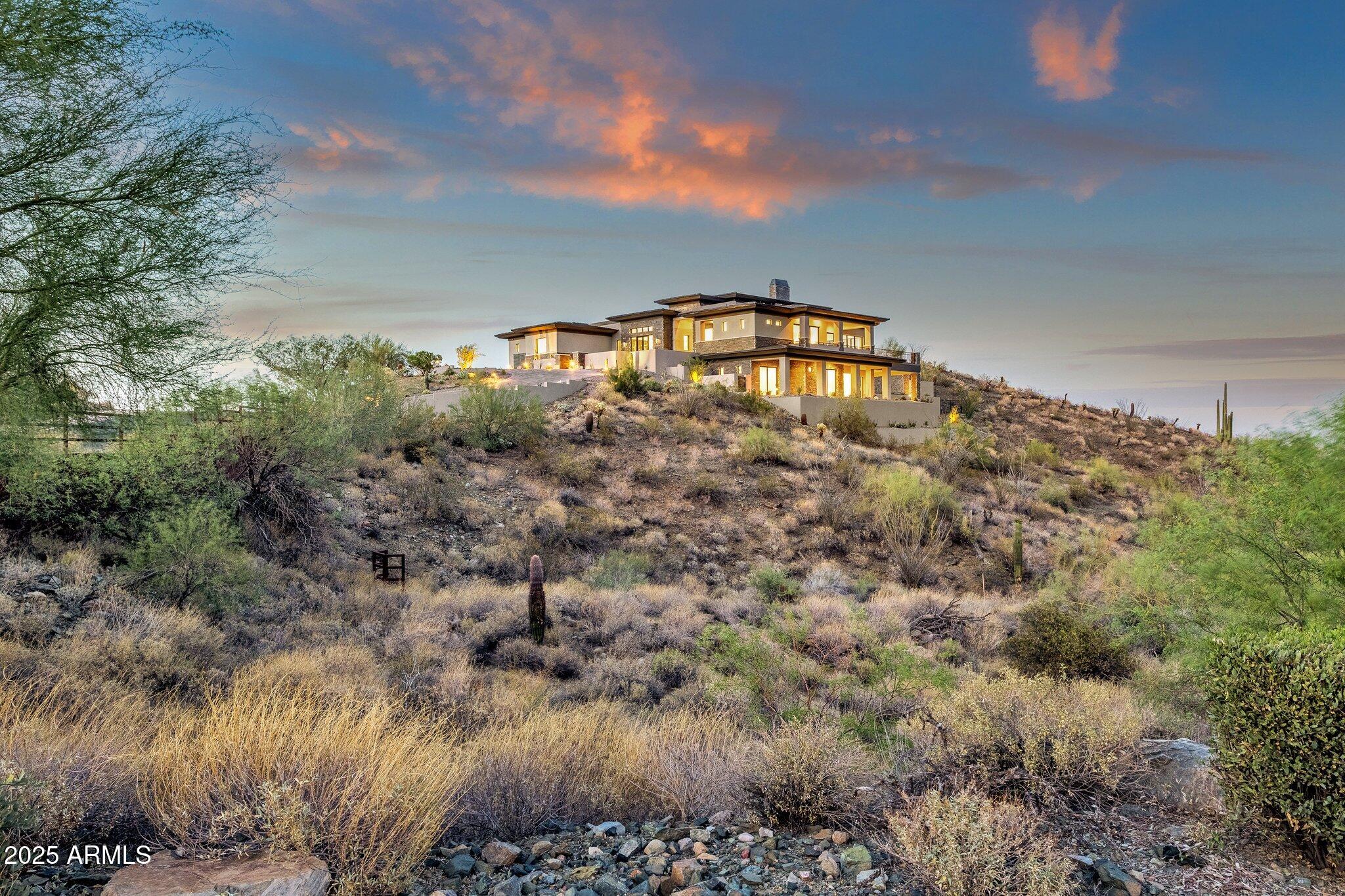 Experience elevated desert living at Eagles Nest with this exceptional new construction opportunity. Perfectly positioned on a large lot overlooking the Superstition Mountains, this contemporary residence captures sweeping mountain, city light, and Sonoran Desert views from nearly every angle. Thoughtfully designed for Arizona indoor/outdoor living, the home features expansive glass, open-concept living spaces, and seamless transitions to outdoor entertaining areas. Located within one of Fountain Hills' premier gated communities, the property offers privacy, stunning natural surroundings, and high-end new construction finishes, all while maximizing the panoramic views that make Eagles Nest so desirable.