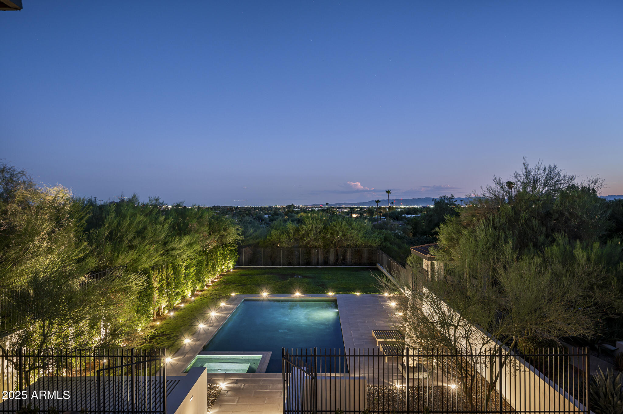 Set on a quiet acre in the heart of Paradise Valley, this hillside estate blends privacy, scale, and sweeping Camelback views into one extraordinary property. With over 8,700 sq. ft. of living space, the home offers 5 bedrooms, 7 bathrooms, and a layout designed for both grand entertaining and everyday comfort.
From the moment you enter, walls of glass frame dramatic vistas of Camelback Mountain and city lights, creating a constant connection to the landscape. The main level is anchored by an impressive chef's kitchen with premium appliances, generous prep space, and an open flow into the living and dining areas. The 1,700 sq. ft. primary wing is a sanctuary of its own, offering ample space, serene views, and a spa-like bath retreat. An elevator connects to the lower level, where guests are treated to private hillside suites, lounge areas, and a dedicated golf simulator room. Outdoors, the resort-style setting has been recently reimagined with new hardscape, lighting, and landscaping. A large flat lawn- a rare amenity for hillside living- surrounds the sparkling pool and spa, while multiple patios and seating areas invite year-round entertaining.
Recent upgrades also include remodeled bathrooms, updated interior doors, and enhanced outdoor spaces that elevate the home's timeless design. With nearly two undeveloped acres bordering the property, the setting feels both expansive and secluded, offering unmatched tranquility.
All of this is located just minutes from Scottsdale and Paradise Valley's finest dining, shopping, and resorts, with convenient access to Phoenix Sky Harbor Airport. This is an exceptional opportunity to own a property that balances luxury, privacy, and convenience in one of Arizona's most prestigious zip code.