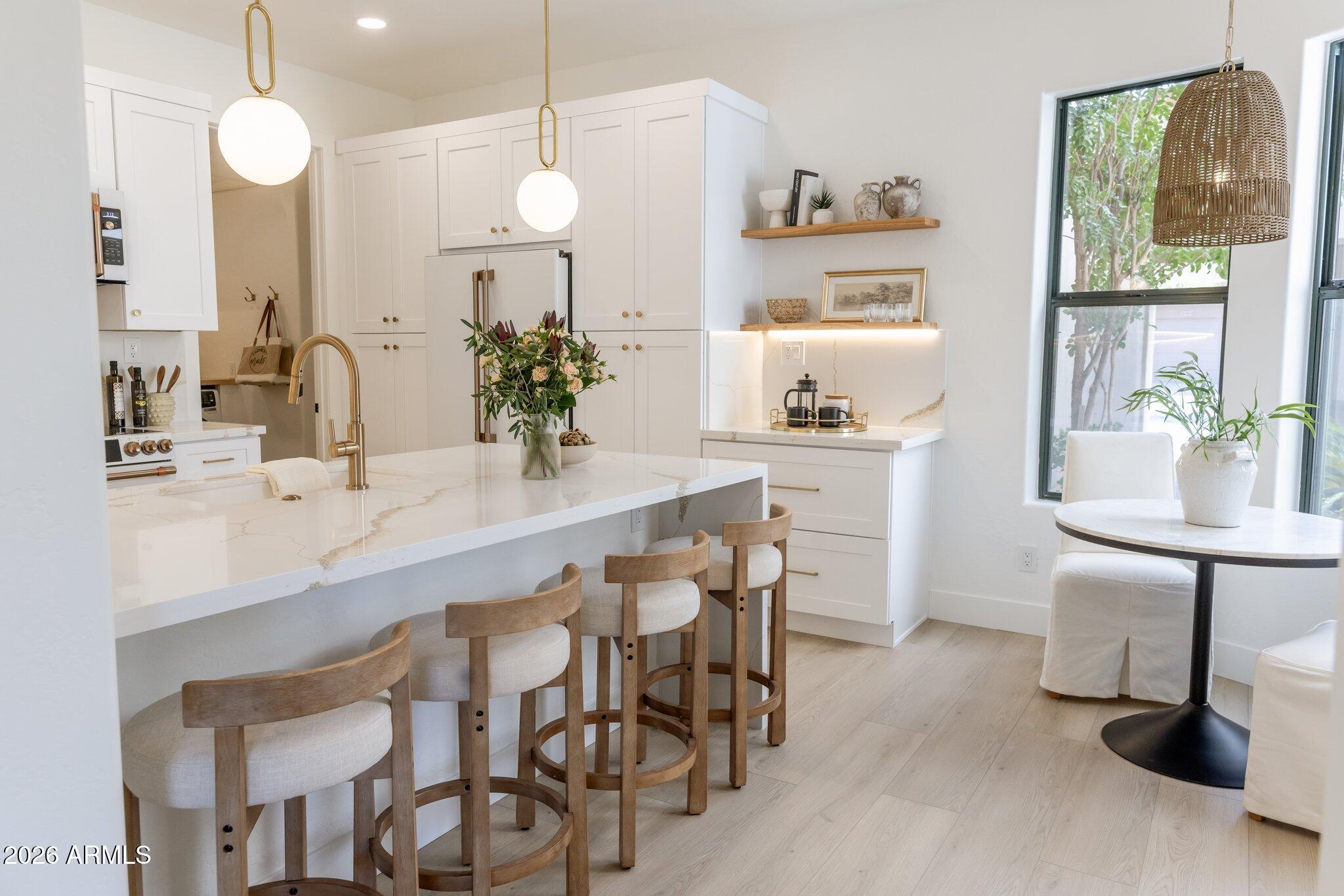 Welcome to the Villas of Cachet at Grayhawk, one of Scottsdale's most sought-after communities. Located within a guard-gated neighborhood, this beautifully renovated townhome blends luxury, comfort, and convenience, making it ideal as a full-time residence or an easy lock-and-leave seasonal retreat. 
From the moment you arrive, there is an undeniable sense of exclusivity and ease, with resort-style amenities and tranquility that feel worlds away yet moments from everything North Scottsdale has to offer.
Residents enjoy access to a heated pool and 2 spas, a fitness center, tennis courts, basketball courts, and miles of scenic walking paths woven throughout one of North Scottsdale's most desirable master-planned communities. With 24-hour security patrol, a guard-gated entrance, and a charming gated courtyard setting, this home offers privacy, comfort, and a true North Scottsdale lifestyle. Beautifully reimagined with high-end curated upgrades, this is far more than a full remodel; it is a complete transformation designed for those who appreciate thoughtful design and craftsmanship. Offering 3 beautifully renovated bedrooms and 2 baths, the home feels intentional, elevated, and designed for modern living. Wide-plank luxury vinyl flooring runs seamlessly throughout, grounding the home in warmth and cohesion. Upgraded baseboards, custom doors with hardware, designer lighting, and polished champagne gold plumbing fixtures add layers of sophistication, while marble-inspired finishes bring softness and understated elegance throughout.At the center of the home, a stunning floor-to-ceiling porcelain fireplace draws the eye upward, creating a grand yet welcoming atmosphere.  Just beyond, a custom beverage bar with built-in wine refrigeration and LED-lit floating shelves creates the perfect backdrop for effortless entertaining. Whether hosting intimate evenings with friends or unwinding with a glass of wine after a day on the golf course. The kitchen blends elevated design with everyday function in all the right ways. Anchored by a premium Café appliance suite in Matte White and brushed-bronze hardware.  Soft, warm, and quietly luxurious, the matte white finish creates a fresh, elevated aesthetic that pairs beautifully with quartz countertops, crisp cabinetry, and designer floating shelves, offering extensive storage space and a timeless designer feel.
The owner's suite is a true sanctuary, private, serene, and deeply restorative. Designed to feel like a boutique resort retreat, this space invites relaxation from the moment you enter. Private access to its own patio with views of the McDowell Mountains creates the perfect setting for slow mornings, peaceful evenings, and breathtaking Arizona sunsets painted across the desert sky.
The primary bath evokes a sense of quiet luxury. The freestanding soaking tub serves as a sculptural centerpiece, crowned by a breathtaking chandelier crafted from solid wood beads. The soft glow filtering through its organic textures creates warmth and ambiance, transforming the space into a peaceful retreat designed for restoration.A custom walk-in shower and elegant designer fixtures further elevate the experience, while an exquisite Thassos Herringbone honed marble mosaic introduces a level of refinement rarely found. Sourced from the Greek islands, it features a soft matte finish and an intricate herringbone pattern that brings depth, texture, and timeless sophistication, wrapping the bath in an atmosphere that feels both luxurious and tranquil. Completing the suite is a walk-in closet with a custom organizational system that seamlessly blends beauty and function. The secondary bedrooms offer versatility for guests, family, or a sophisticated home office.The secondary bathroom delivers its own elevated spa-like experience with a striking floating double vanity enhanced by under-cabinet lighting, creating a soft ambient glow and a clean modern aesthetic. Clean architectural lines are complemented by thoughtfully layered textures and warm neutral tones, creating a soothing, earthy feel while delivering both visual interest and function. The result is a space that feels grounded, calming, and effortlessly luxurious.
An attached two-car garage adds convenience and value, complete with brand-new epoxy flooring and built-in storage for a polished, functional finish.
Situated in the heart of Grayhawk, this home places you within minutes of North Scottsdale's most celebrated dining, shopping, golf, and entertainment. Enjoy walking distance to Grayhawk Golf Club, Isabella's Kitchen, Quill Creek Café, and AJ's Fine Foods.
Just minutes away, DC Ranch Marketplace, Scottsdale Quarter, and Kierland Commons offer some of Scottsdale's finest luxury shopping, dining, and lifestyle experiences. Easy access to the Loop 101 places the entire Valley within effortless reach, connecting you quickly to world-class championship golf, upscale dining, Sky Harbor Airport, and everything Scottsdale and Phoenix have to offer. A rare offering where luxury, lifestyle, and location align beautifully.