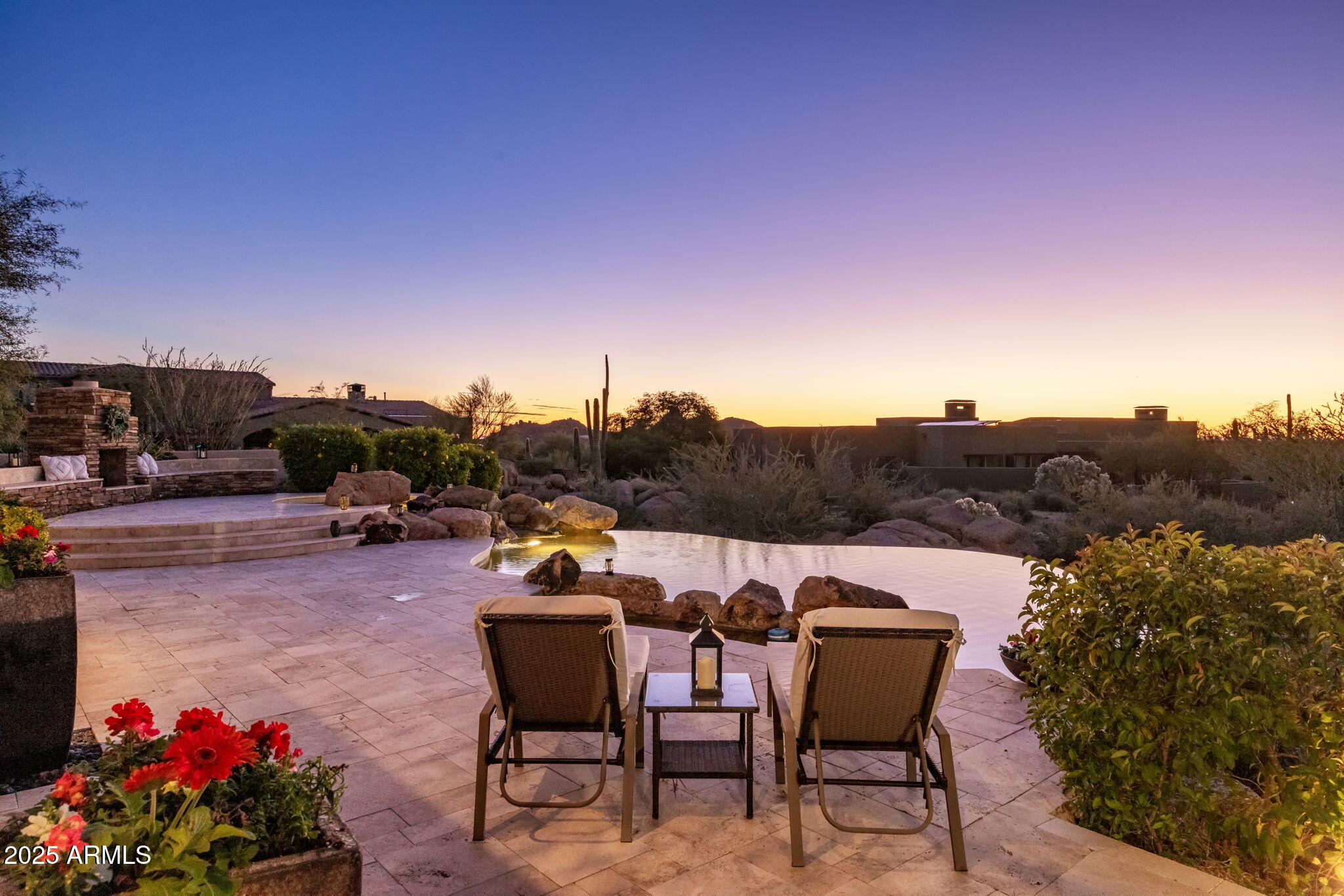 Set within the gated community of Boulder Crest at Troon North, this expansive desert estate is ideally suited for multi-generational living, large families, or retreat-style gatherings, offering exceptional scale, privacy, and flexibility. With six bedrooms and six-and-a-half baths, the thoughtfully designed floor plan allows multiple households or guests to comfortably coexist while maintaining both privacy and connection. The resort-style backyard is truly special, featuring a negative-edge pool, expansive patios, and outdoor gas fireplace, along with a built-in BBQ bar complete with a gas fire pit. Multiple seating areas are perfectly positioned to capture sweeping mountain and full city-light views, as well as Arizona's iconic sunsets set against a dramatic, boulder-studded desert landscape. Located just moments from world-class golf, hiking, dining, and shopping, this property embodies the elevated Troon North lifestyle while offering a peaceful desert sanctuary.