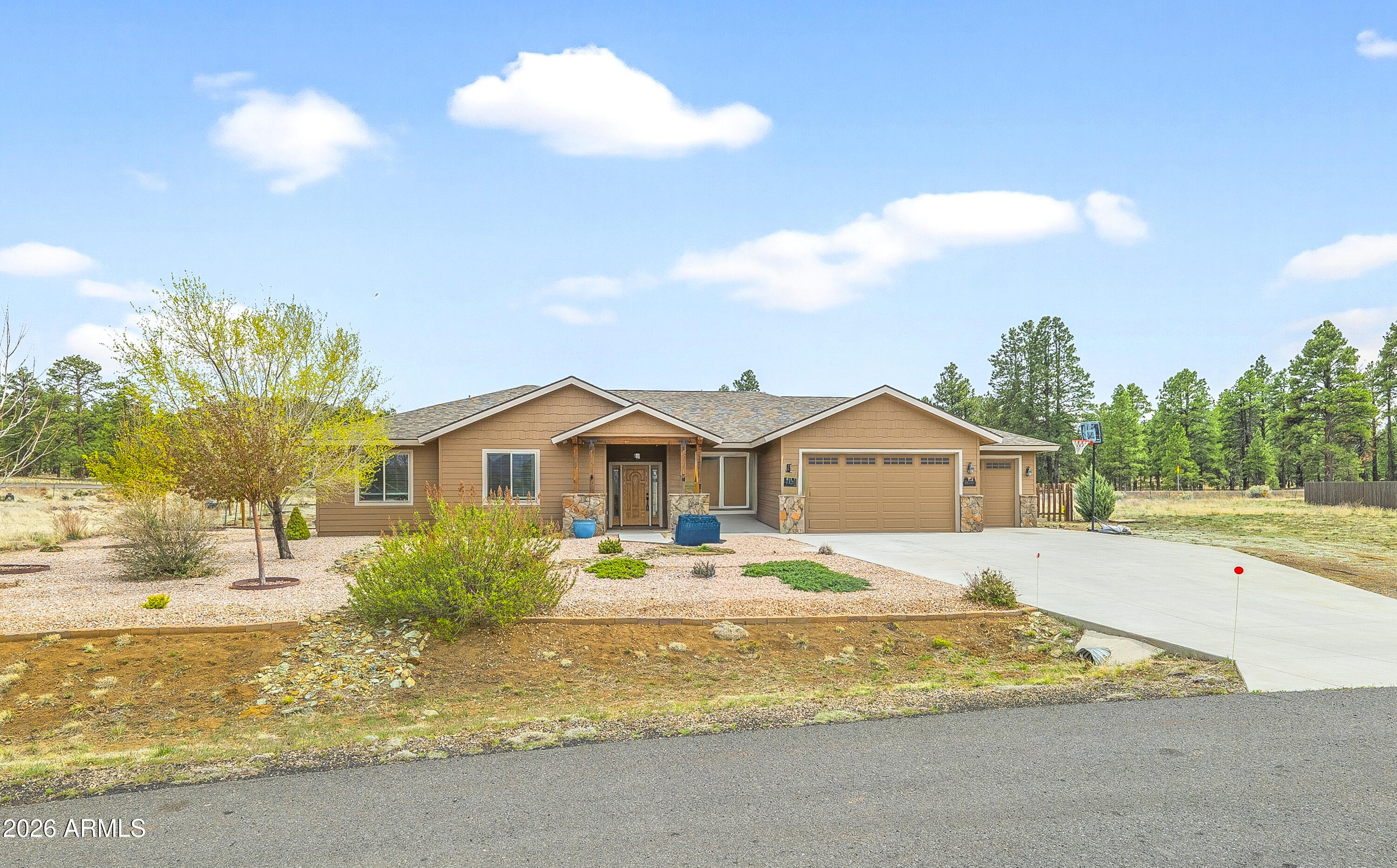 SELLER OFFERING 10,000 TOWARDS BUYERS BUYDOWN. This beautifully maintained single-level home in the desirable Johnson Ranch neighborhood offers 4 bedrooms, 3 bathrooms, and a spacious open floor plan designed for comfortable living & effortless entertaining. The heart of the home is the great room, boasting vaulted ceilings, a cozy gas fireplace, and a dining area that offers breathtaking views of the San Francisco Peaks.Built in 2017 and equipped with central air conditioning, this home combines modern comfort with the peaceful charm of country living. Beyond the interior, the 3-car garage provides ample storage and the expansive fenced backyard offers the perfect space for gardening, complete with mature fruit trees, vibrant summer-blooming roses, and productive strawberry and raspberry bushes. With RV parking and plenty of room for outdoor recreation, there's space for all your toys and hobbies.  Forest trails are nearby for daily adventure, and county-maintained neighborhood roads plus highway access put shopping, medical, and university facilities just 10-20 minutes away.  Forget the hassles of propane or water hauling; this home is connected to natural gas and Doney Park water. If you're looking for the quiet country lifestyle without sacrificing city convenience, this home is for you!