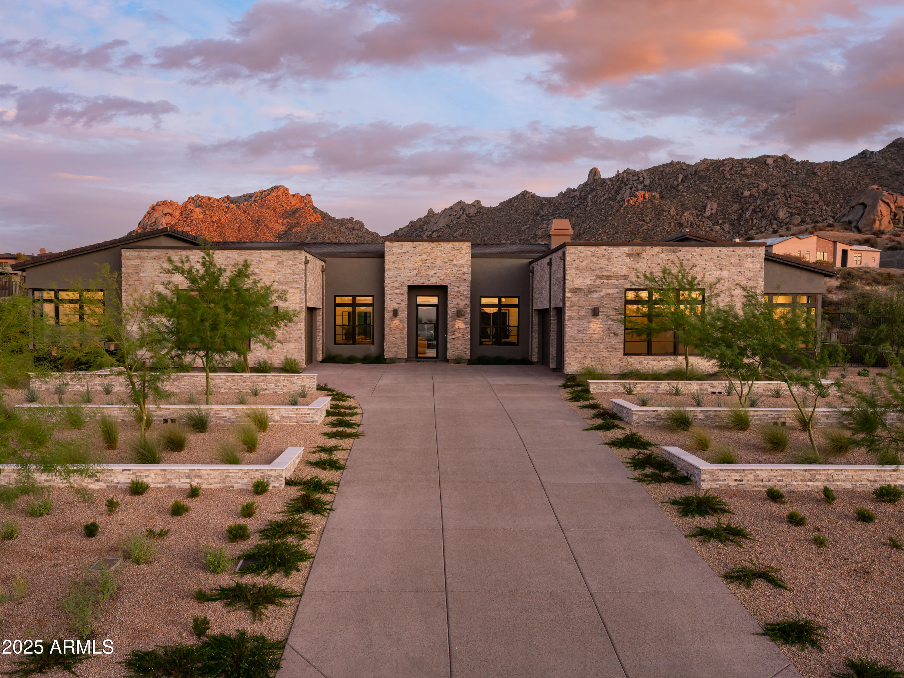 This home is straight out of a magazine! From the moment you step inside, you'll be captivated by its stunning finishes and resort-style backyard. The open-concept layout makes it an entertainer's dream. The kitchen boasts dual waterfall islands that create a bold statement. In the great room, relax by the wall fireplace or step outside to tiered landscaping and a firepit in the pool! The primary suite offers backyard views, outdoor access, a spa-inspired bath, and a walk-in closet. Additional bedrooms showcase mountain views. A detached two-room, light-drenched casita features stacking multi-slide doors with direct pool access and outdoor enhancements. With exceptional privacy and remarkable detail, this home is your own desert oasis.
