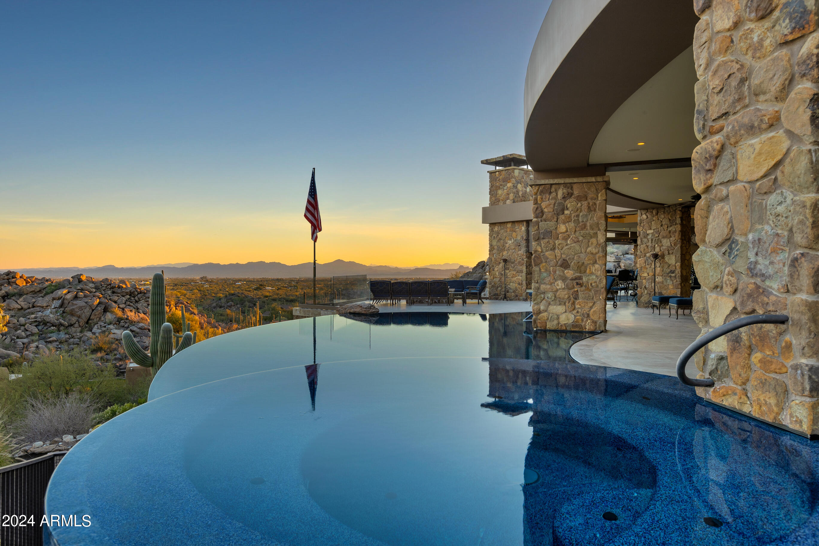 The jewel of prestigious Stone Canyon, this magnificent ridgetop estate spans a sprawling 2.18-acre lot with more than 9,500 sqft of living space, boasts breathtaking panoramic views sweeping from downtown Tucson across the impressive Santa Catalina Mountains to Mt Lemmon, and offers an exquisite living experience second to none. Lavishly appointed with rich hardwoods, intricate stonework, and crystal chandeliers, the home provides dramatic entertaining spaces that flow out to the 2400 sqft covered patio perched over the desert below.
The 8111 sqft four-bedroom, five-bathroom main house and 1442 sqft two-bedroom, two-bathroom guest house were tastefully designed by renowned architect Ron Robinette.  Meticulously crafted with uncompromising quality, this luxurious masterpiece is ready ready to welcome you home.
The main house boasts an impressive rotunda foyer, flowing indoor-outdoor entertainment space, and a dream chef's kitchen with adjacent catering kitchen. 
The living room is anchored on one end by a stately herringbone-patterned limestone fireplace, and is framed by a crescent wall of windows to take in the breathtaking views - perfect for hosting elegant gatherings or enjoying peaceful evenings with family. The expansive room curves around, offering space for a grand piano and additional sitting area, and flows into the elegant formal dining room featuring coffered ceilings and crystal chandeliers that lower smoothly for cleaning.
Filled with top of the line appliances from Gaggenau, Miele, Sub-Zero, and Thermador the kitchen is a canvas to create culinary masterpieces.  With an array of stacked cabinets below clerestory windows and two impressive islands below a coffered ceiling, the kitchen is the cozy heart of the home.  It overlooks the family room that converts to a theater room at the touch of a button. 
 The sophisticated owner's suite is a spa-inspired oasis of peace and serenity, with walls of windows to take in the breathtaking vistas, an impressive limestone corner fireplace, private patio access, and a luxurious ensuite featuring a steam shower, drying room, soaking tub, Numi water closet and opulent closet/dressing room.
The artfully imagined patio is designed to maximize the views beyond with a stunning glass patio railing system that gives the feeling of being able to step into the desert. Whether entertaining large parties into the night or in cozy contemplation, you will be treated to jaw-dropping vistas that stretch for miles. The luxurious, resort-style infinity edge pool and spa seemingly merge with the surrounding landscape aside a footbridge and tranquil water feature. 
The covered outdoor kitchen has everything imaginable- built-in BBQ, cooktop, warming drawer, refrigerator, dishwasher, and sink with a bar peninsula. Adjacent, under the expansive covered portion, lies a fireplace and television, and beyond a large firepit to enjoy the evening lights. 
The enchanting library maintains the same standard of luxury as the rest of the home, with floor-to-ceiling custom walnut cabinetry, dual work stations, library shelving with dual sliding ladders, and room for a sitting area. Dark walnut moulding extends across the coffered ceiling for a truly old-world, castle-like feel.
The main house is completed with two additional ensuite bedrooms, an exercise room/4th bedroom, all with custom walk-in closets, and an oversized garage with multiple storage room and the ultimate workshop/man cave.
Your guests will luxuriate in the resort-like detached guest house with game room. Meticulously crafted with uncompromising quality, two bedrooms, two bathrooms, a full kitchen and laundry, a family room showcasing the views though a wall of windows and a private patio.
The home features its own private park complete with snake-proof fencing, a fire pit, and dog run. The area also cleverly hides an underground 1000 gallon propane tank that supplies the emergency generator.
Smart technology abounds: Lutron light and shade systems - create the perfect amount of light at the touch of a button. There is also an Accura monitored security system; a  HikVision camera system with DVR recording; Sonos audio system; and a commercial grade networking system upgraded in 2023.  
The Jewel of Stone Canyon House -- it's not just a home; it's a lifestyle statement. It's where luxury meets comfort, where every day feels like a retreat, and where you can truly live your best life. Welcome to your dream home - where every moment is an experience in unparalleled luxury and elegance.