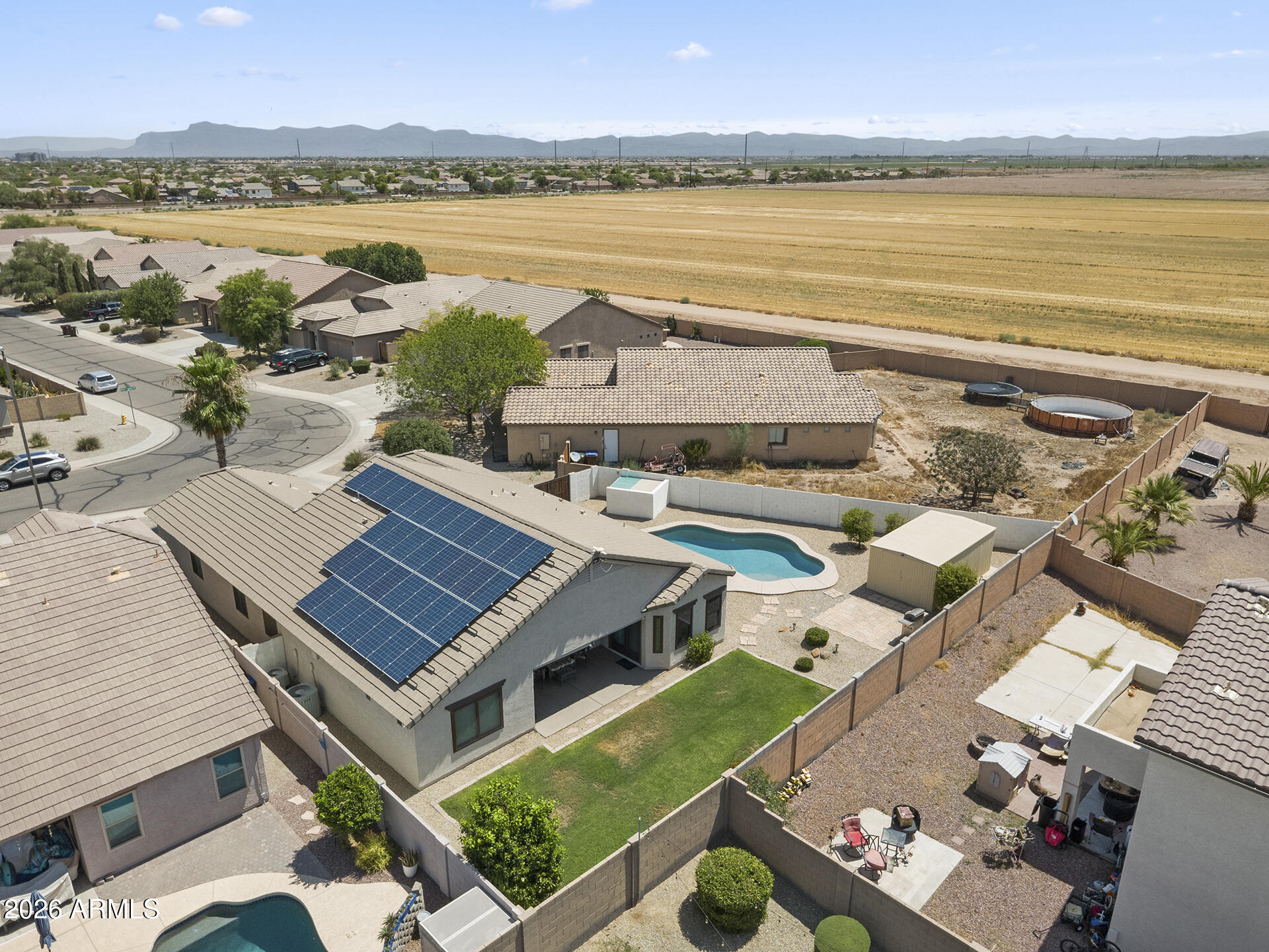 SALT WATER POOL, CASITA & NO MONTHLY SOLAR PAYMENTS! This well-maintained San Tan Valley home offers an open-concept layout with vaulted ceilings, large tile flooring throughout the main living areas, abundant natural light from Andersen Windows & low maintenance living. The spacious living room flows seamlessly into the updated kitchen featuring granite countertops, cabinetry with pullout drawers, tile backsplash, a large center island with breakfast bar seating, dual built-in wall ovens, electric cooktop, walk-in pantry & generous dining area with a large Andersen sliding door to the backyard. The large primary suite has backyard access & an ensuite showcasing dual vanities, a soaking tub, walk-in shower & walk-in closet. Two additional bedrooms share a full hall bath. A casita with its own living area, wet bar / possible kitchenette, bedroom & full bath provides the perfect space for guests, multi-generational living, a home office or flexible bonus space. The large backyard has been completely transformed with a sparkling saltwater pool, real grass & grapefruit tree, covered patio with shades & ceiling fan & insulated work shed. Additional highlights include an indoor laundry room, whole-home water filtration & soft water systems, a fully paid solar lease with no monthly payments & insulated 2 car garage with new hot water heater! Located in a community with parks, greenbelts, playgrounds, basketball & sand volleyball courts. Home is a short distance from Skyline Ranch Elementary, new stores with shopping, dining & other recreation.
