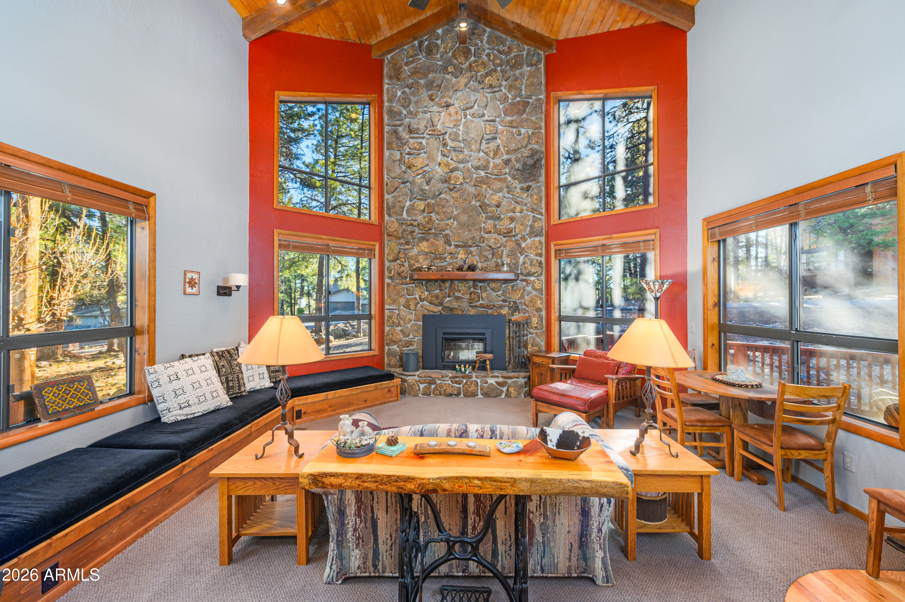This beautifully maintained Munds Park chalet-style cabin is being offered fully furnished and is ready for you to start enjoying right away. The main level features two spacious bedrooms and two updated bathrooms, providing comfortable accommodations for family and guests. Upstairs, the oversized loft offers flexible space that can serve as a bunk room, game room, home office, or additional sleeping area. Inside, you'll find warm wood flooring, custom built-in bench seating in the great room, and an open, spacious kitchen designed for gathering and entertaining. The stunning floor-to-ceiling stone-faced wood burning fireplace creates a dramatic focal point and adds to the cabin's cozy mountain charm. Front and back decks provide plenty of space to relax, entertain, and enjoy the beautiful mountain setting.