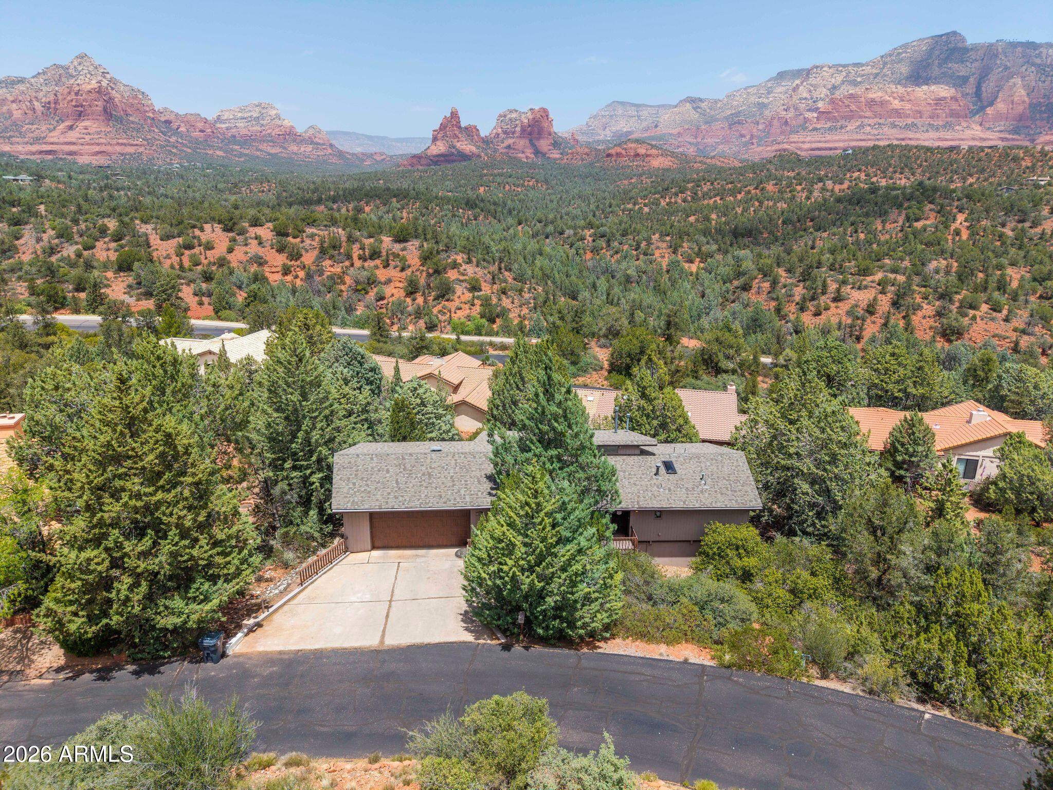 Experience the beauty of Sedona living in this stunning home surrounded by breathtaking red rock views from the private back balcony and throughout the scenic neighborhood drives. Thoughtfully updated from top to bottom, this property blends luxury, comfort, and versatility in one incredible setting. Step inside to find new luxury vinyl plank flooring and carpet installed in 2021, along with tinted energy-efficient windows that block 85% of UV rays while helping reduce electricity costs. The primary suite offers a beautifully remodeled bathroom featuring marble countertops, updated flooring, and a luxurious soaking tub designed for relaxation. Major upgrades provide peace of mind, including a new roof (2025) with a 35-year warranty, HVAC system replaced in 2025 with a 10-year warranty, water heater replaced in 2022, new garage door, and a stunning new stone gas fireplace installed in May 2026. Brand new Anderson doors were also added for both the upstairs and downstairs side entrances. The downstairs level offers a fully equipped private living space with its own entrance, kitchen, living room, spacious primary bedroom, and beautifully renovated bathroom--perfect for guests, multigenerational living, or potential rental opportunities. The downstairs kitchen features a new dishwasher and elegant marble tile countertops, while both upstairs and downstairs bathrooms were completely renovated in 2025. Outdoor living is just as impressive with a Trex deck ideal for enjoying Sedona's iconic sunsets and unforgettable red rock scenery. This home truly captures the essence of luxury Sedona living with thoughtful upgrades, flexible living space, and views that will leave you speechless.