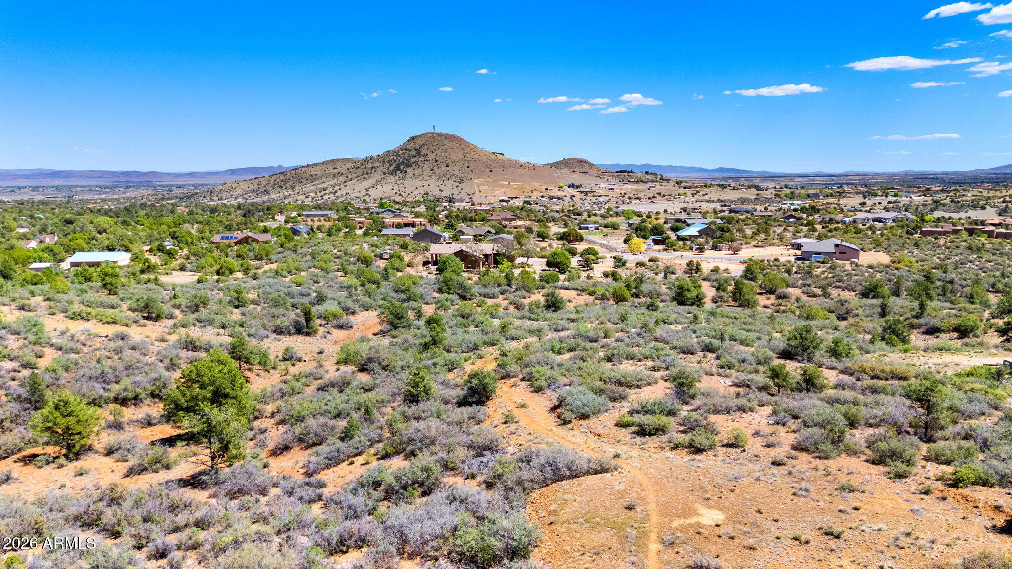 Looking for panoramic views and peaceful surroundings? This stunning 5-acre parcel offers breathtaking sights of Granite Mountain, Bill Williams Mountain, the San Francisco Peaks, and the beautiful valley between. Surrounded by rock outcroppings and natural high-desert vegetation, this raw land is full of potential. Two dirt roads provide access—one with a cut-in and level pad for easy turnaround. County allows for the property to be split. Come explore—this could be the perfect perch for your new Arizona home.