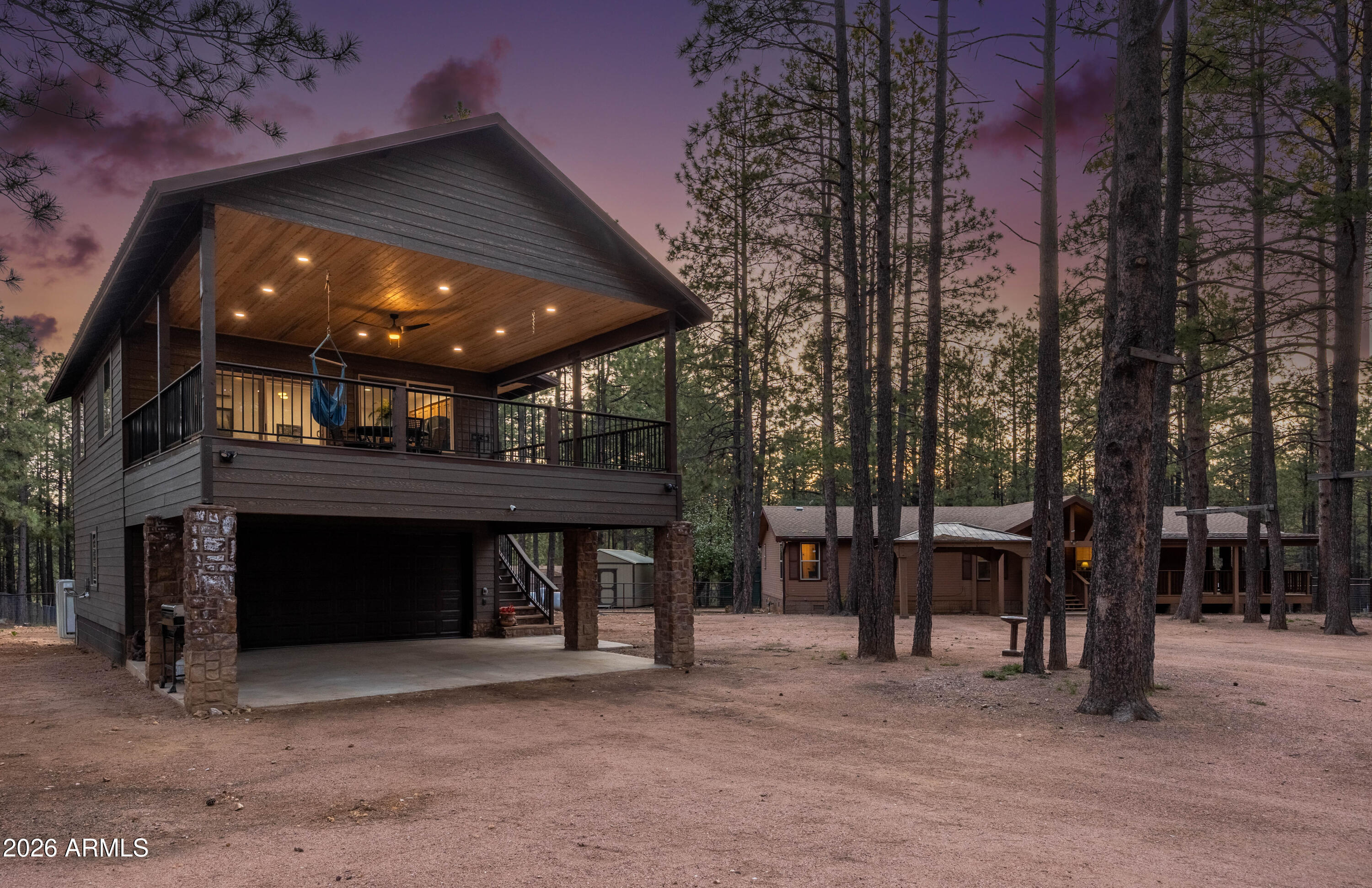 Nestled upon a full acre of Arizona's most coveted terrain, this extraordinary estate transcends the ordinary, delivering an unparalleled sanctuary where refined living harmonizes with the untamed grandeur of the Mogollon Rim country. This compound presents a rare gathering of amenities, anchored by two distinct residences, dual garages, and an expanse of outdoor space that beckons the soul. The breathtaking guest quarters, masterfully constructed in 2024 above an impeccably finished garage, elevates mountain hospitality to an art form. Within, soaring ceilings adorned with recessed lighting illuminate a chef's kitchen of extraordinary caliber, featuring lustrous granite countertops, soft-close cabinetry, and premium stainless steel appliances. A sophisticated mini-split system ensures year-round comfort, while an expansive elevated Trex deck, crowned with exquisite tongue-and-groove ceilings, offers a perfect perch from which to witness nature's theater unfold.

The primary residence, a thoughtfully appointed Cavco home, embraces an open great room concept designed for effortless gathering and entertainment. The stylish kitchen boasts a generous walk-in pantry, complemented by a dedicated laundry area and two spacious bedrooms featuring walk-in closets and well-appointed bathrooms. A versatile third room, equally suited as a private bedroom or distinguished home office, ensures adaptability for every chapter of life. An expansive Trex deck wraps the home in seamless indoor-outdoor elegance.

Beyond the residences, this property reveals layer upon layer of amenities from Multiple storage sheds, a fully fenced backyard, and a dedicated corral suitable for horses or pets establish genuine compound functionality. The larger garage arrives equipped with a Fluxe electric vehicle charger, Mr. Heater BIG MAXX Heater and wall mount Chamberlain opener, while a Generac 22kw generator promises unwavering energy independence for both homes. Fruit-bearing apple trees and plum tree punctuate the landscape with charm, and a substantial [gun] safe secures your most treasured possessions.

Delivered fully furnished, this estate positions you mere moments from multiple trout stocked waters of Willow Springs Lake, Woods Canyon Lake, and more. Plus the awe-inspiring vistas of the Mogollon Rim Visitor Center, where Arizona's high country reveals its most magnificent expression.

Opportunities of this magnitude and distinction in Forest Lakes Estates emerge with extraordinary rarity. This is not merely a property; it is an invitation to claim your own private mountain kingdom.