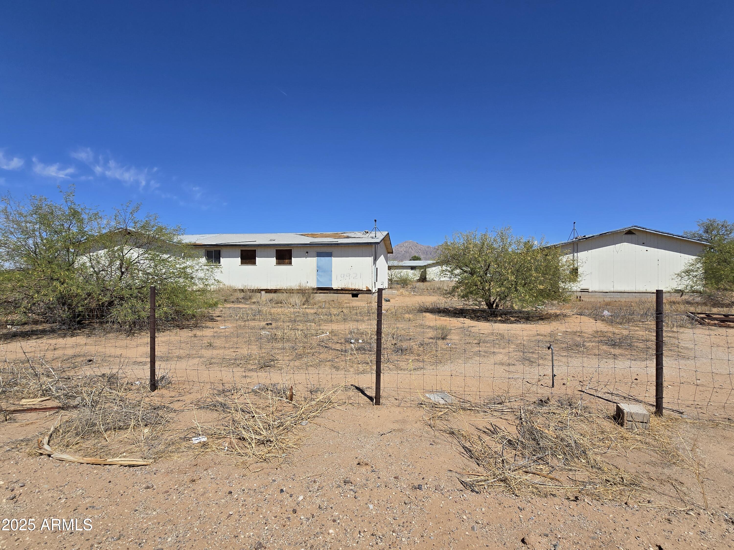 Improved land with 3 structures. 2 structure are attached that equal 2,008 sq ft. 1 detached building that has 1,004 sq ft. Each building has 2 bathroom and no bedrooms. The structures were formly used as school houses that have been relocated to this location. Permits have expired though Pinal County. The building have never been connected to services. This is a great investment opportunity with massive potential for an investor!