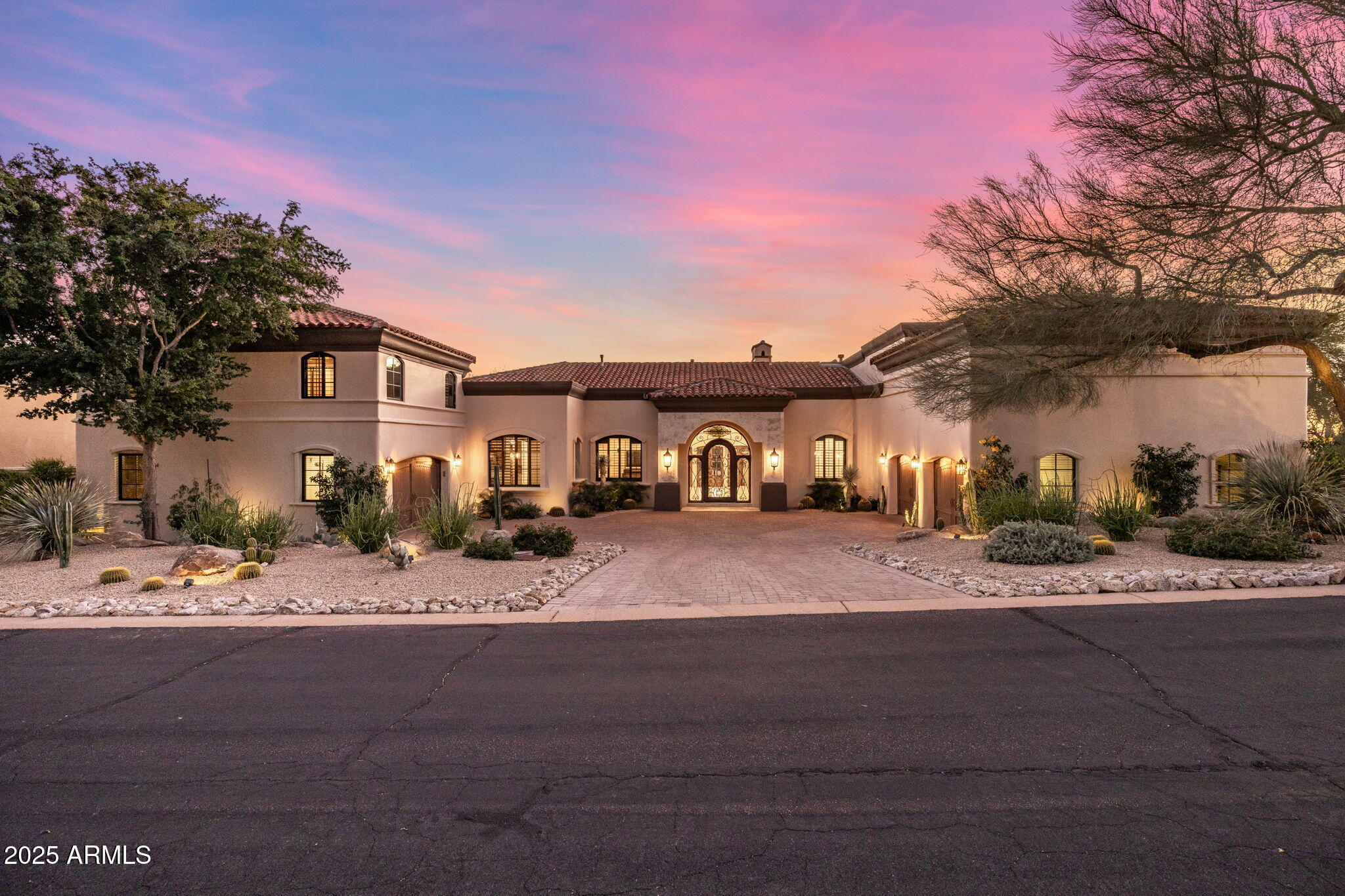 Introducing The Sunset Fire Estate! A stunning 7,200+ SF custom luxury residence located within the prestigious guard-gated enclave of Artesano at Troon Canyon. Offering elevated desert living, dramatic mountain and sunset views, and unmatched proximity to Troon Country Club, this meticulously maintained home delivers a rare blend of architectural presence, comfort, and lifestyle-driven design. Designed for both grand entertaining and everyday living, the residence features soaring ceilings and expansive living spaces that flow seamlessly throughout. The chef's kitchen is exceptionally appointed for serious cooking and effortless hosting, complete with three ovens, two dishwashers, a bread warmer, walk-in pantry, butler's pantry, full bar with ice maker, and a fully equipped outdoor kitchen. A temperature-controlled wine room, two generous living areas, and a flexible formal dining space further enhance the home's versatility. The thoughtfully designed split floor plan includes four bedrooms plus a fifth ensuite flex room, ideal as a private guest suite, wellness room, or second office. The luxurious primary suite offers a serene retreat, while a separate junior suite is perfect for extended-stay guests. A dedicated office overlooking the front courtyard creates an inspiring work-from-home environment. Completing the interior is a private home gym with direct backyard access, supporting a health-forward lifestyle.
Outdoor living shines with a newly completed resort-style pool and spa (2024) featuring dramatic fire elements perfect for enjoying breathtaking desert sunsets. Additional highlights include a roof approximately five years old, impeccably maintained interior and exterior spaces, and some furnishings available by separate agreement. Residents of Artesano enjoy an exceptional balance of privacy and convenience, surrounded by the McDowell Sonoran Preserve's miles of hiking and biking trails, just minutes from world-class golf, fine dining, boutique shopping, and all that North Scottsdale has to offer. The Sunset Fire Estate is where every day feels like a private desert retreat, an exceptional opportunity not to be missed!