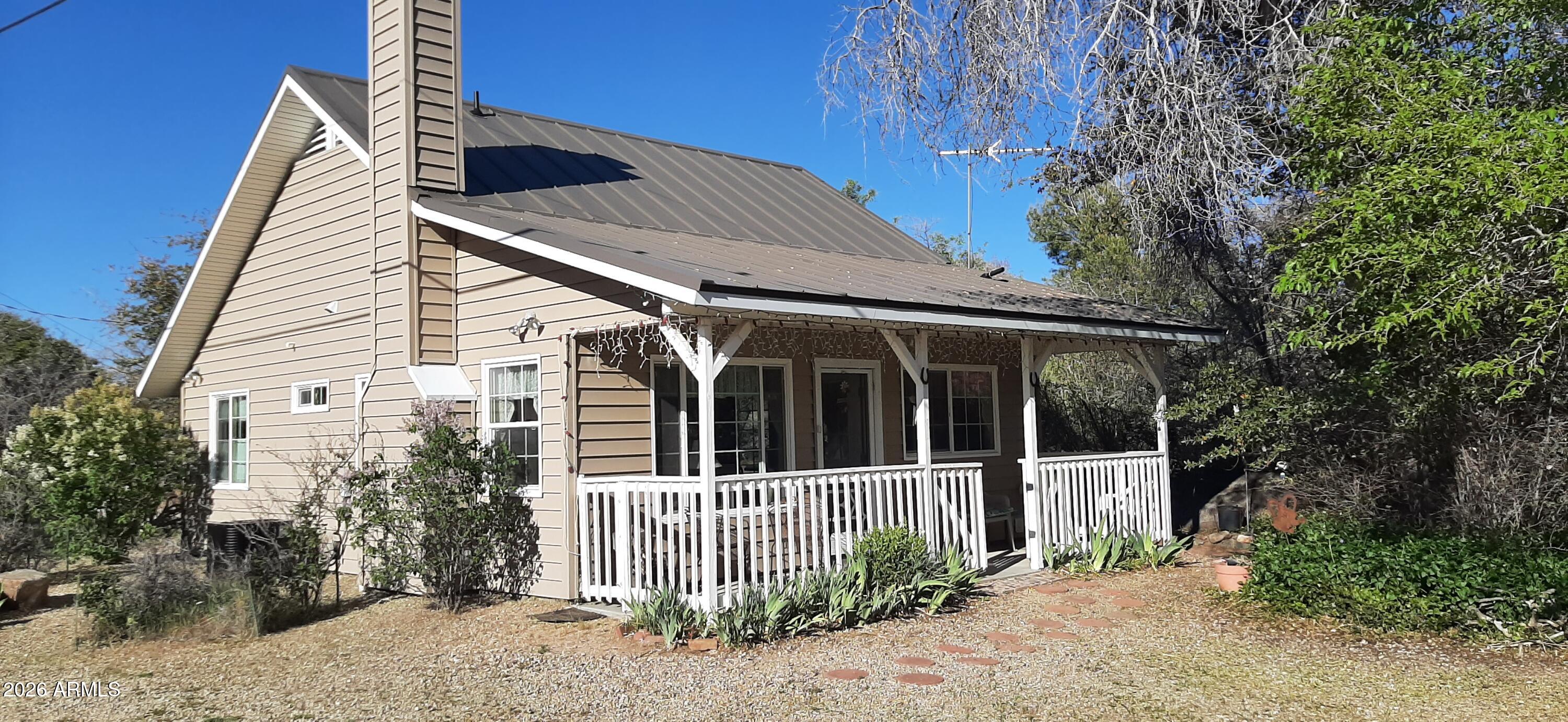 Escape to cooler summer temps & country living in Yarnell. This country home built in 2013 is tucked in amongst a variety of shade trees, lilac bushes, fruit tree and granite boulders. This 2 bd 1 ba home is light & airy with vaulted ceiling, open kitchen and living room area giving this home a spacious feel.  Living room has a wood burning fireplace for cozy winter nights. Kitchen features granite countertops, alder cabinets, kitchen island and kitchen nook with patio door leading out to secret garden area. Quiet covered patio to watch amazing sunsets in the boulder covered mountains. A short distance to Wickenburg & Prescott and about 1.5 hours to Phoenix. No HOA