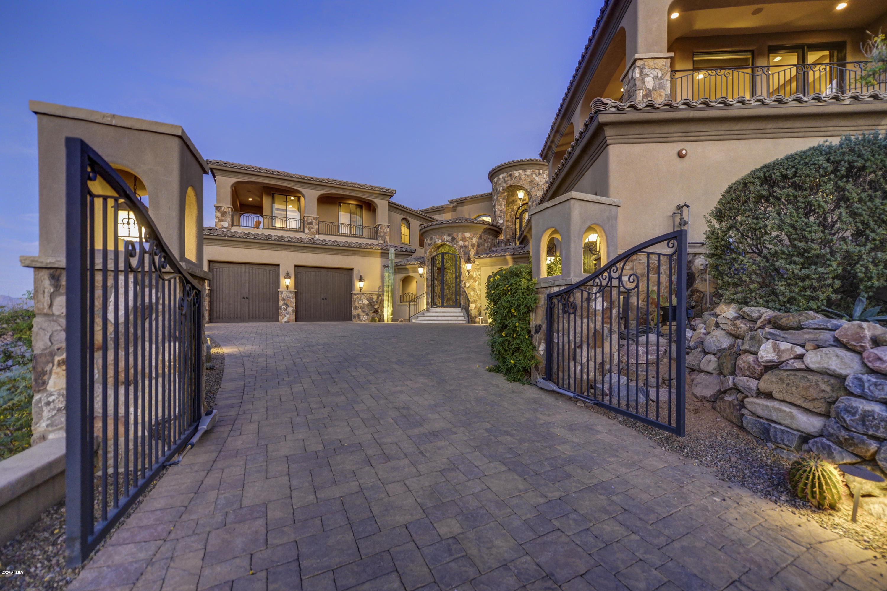 THIS HOME HAS IT ALL!! Be sure to view the Virtual Tours! Truly a MUST see that will not disappoint. Enter your own private gate to a stunning courtyard with beautiful fountain and a double sweeping staircase to the front door or take the elevator. Once inside this home is all on one level.  Unbelievable stonework and massive beamed ceilings. Enjoy a comfortable, open floor plan that is perfectly suited for entertaining with a retractable wall of windows that opens to your patio, AMAZING negative edge diving pool, hot tub, outdoor kitchen, fire pit, the most INCREDIBLE morning sunrises and evening sunsets cascading the endless Mountain View's. Or, how about a retreat to your UPGRADED LUXURY HOME THEATER! Exquisite master suite with a double fireplace and sitting area. Master bathroom with steam shower, heated floors and stone soaking tub. Three additional large, en-suite bedrooms to pamper your guests. Lets not forget the garage with tons of storage, a workbench and a a car lift. This TURNKEY home comes complete with all furnishings included. A luxury surprise awaits you at every part of this home. NOTHING was left out.