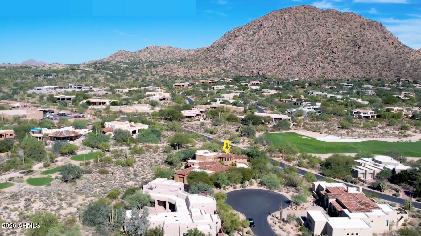 Nestled in a private cul-de-sac on the 4th tee of the renowned Jack Nicklaus Signature golf course in guard-gated Desert Highlands, this custom 2000 built residence offers casual elegance and timeless desert luxury on a spacious 0.75 acre lot.
Boasting approx. 6,361 sq. feet, the home features 4 bedrooms and 4 1/2 bathrooms, including a secluded primary suite, three guest suites, plus an office.  An open and spacious great room flows seamlessly, creating an inviting atmosphere for both relaxed living and elegant entertaining.  
The home showcases picture windows throughout that frame mountain, golf course and city light views while preserving a sense of privacy.
Step into the welcoming courtyard, accented by a magnificent curved copper water feature, fireplace and a private casita .