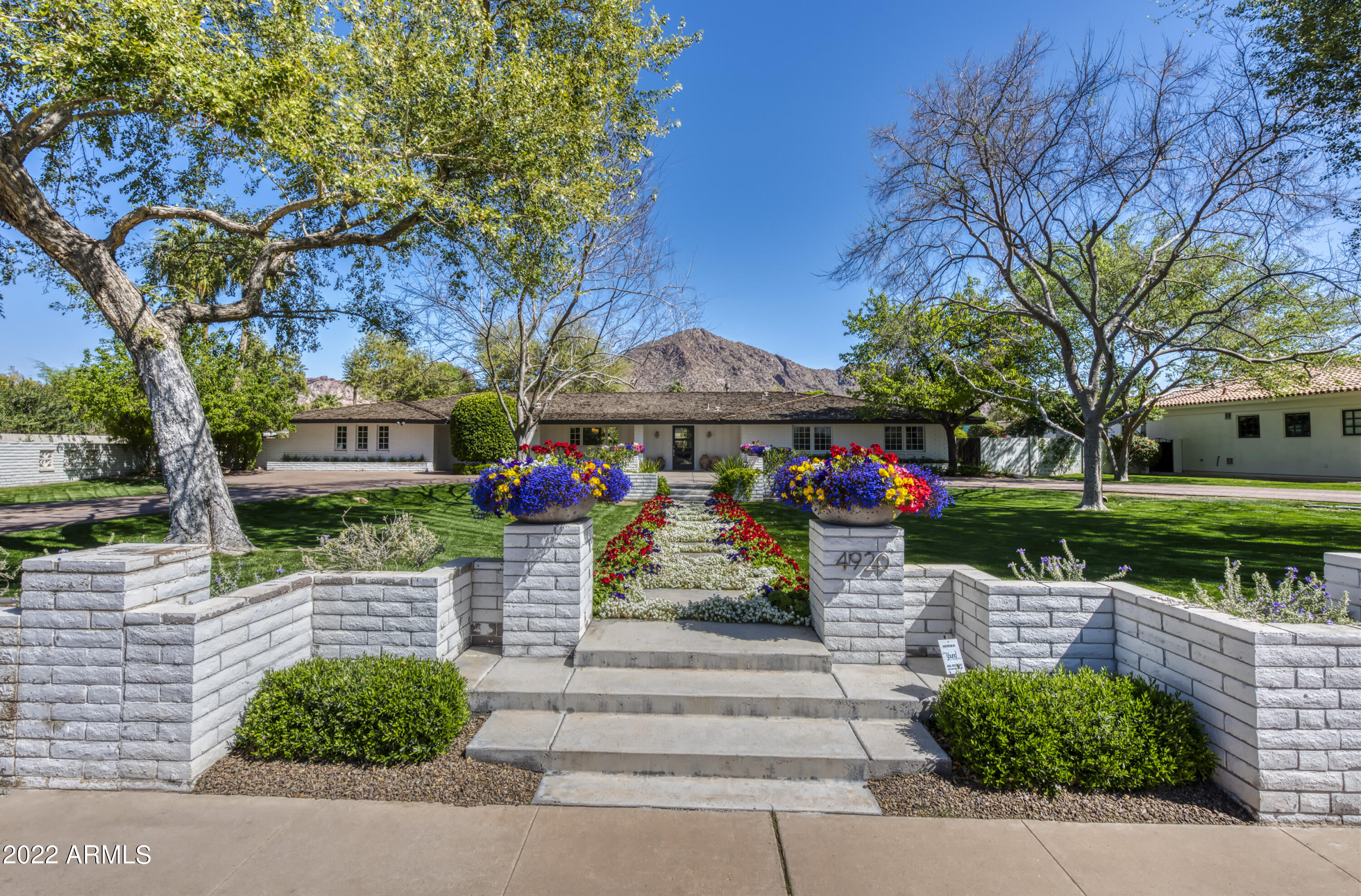 This modern ranch beautifully combines chic architectural elements and unique warmth. Every room has been thoughtfully planned for the ultimate living & entertaining experiences. The chef's kitchen has a butler's pantry with a refrigerator, wet bar & dishwasher, the great room is beautiful, each of the bedrooms and baths have their own distinct charm, and the primary suite is exceptional. The highly impressive finishes include quartz countertops, white oak flooring, substantial millwork, wainscoting, fully retractable doors & complete smart house technology. The stellar half acre lot has mature landscape, a beautiful pool, gazebo, fire pit, custom brick patio, built-in barbecue, and a huge yard with breathtaking mountain views. This outstanding soft contemporary residence is just perfect!