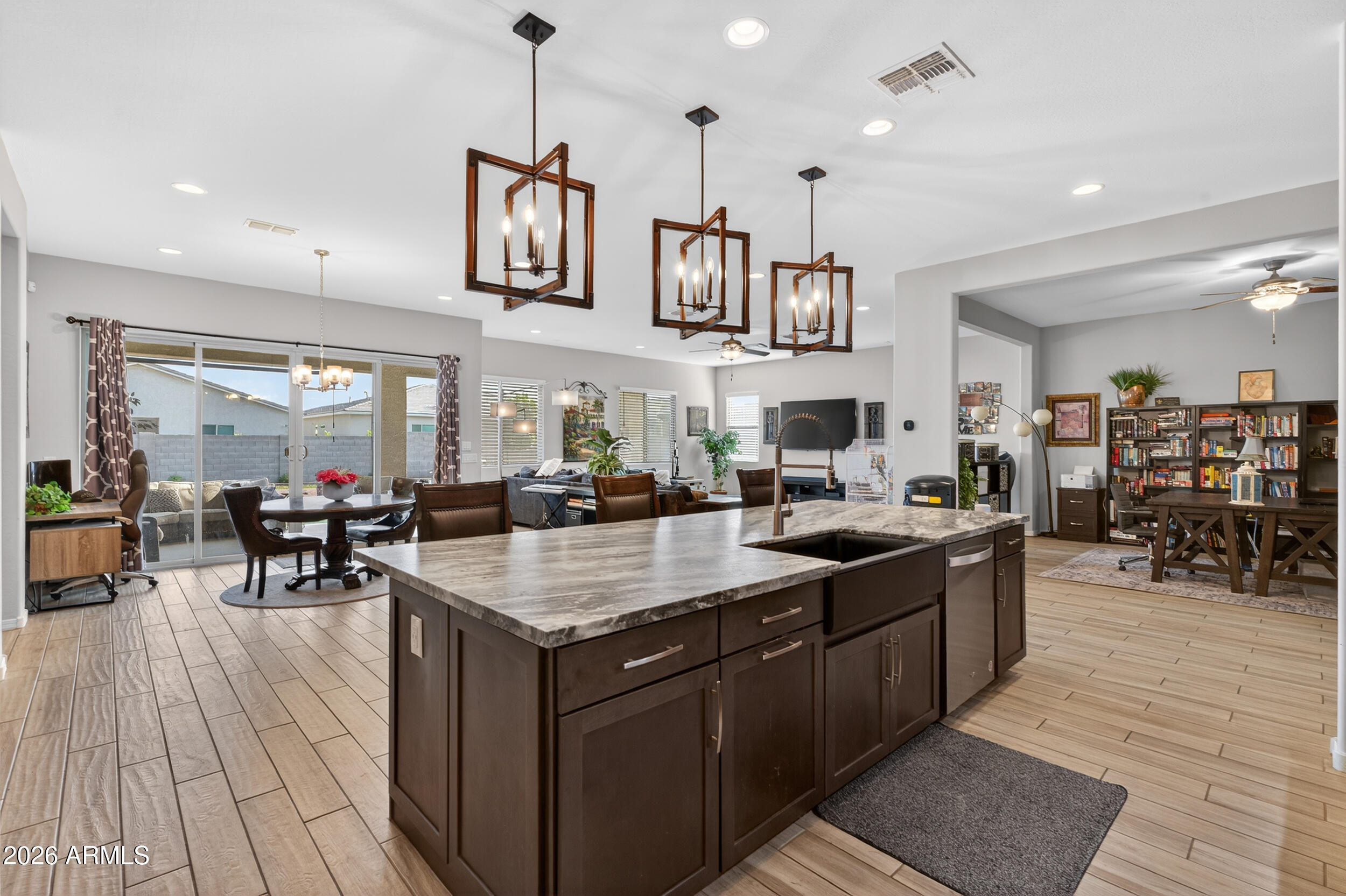 Welcome to Azure Canyon, where functionality meets flexibility in one of the most sought after layouts in the area. This 2023 built home offers a spacious open concept design with a large kitchen island that flows seamlessly into the main living area, creating the perfect space for everyday living and entertaining. What truly sets this home apart is the oversized RV garage that has been thoughtfully converted into a fully functional bonus space complete with its own AC unit, kitchenette, and full bathroom. Whether you're looking for a game room, guest suite, home gym, or multi generational setup, this space offers endless possibilities. The split floor plan is designed with both privacy and convenience in mind, with all bedrooms offering direct bathroom access. One of the secondary bedroom features its own private bathroom, functioning similarly to a second primary suite and ideal for guests or extended living arrangements. A separate bonus living area between the secondary bedrooms adds even more flexibility as a media room, playroom, or home office. The backyard is clean and low maintenance with plenty of room to design your ideal outdoor setup. Located in a growing West Valley community with convenient access to shopping, dining, and freeway access, this home offers the opportunity to move right in without the wait of new construction.