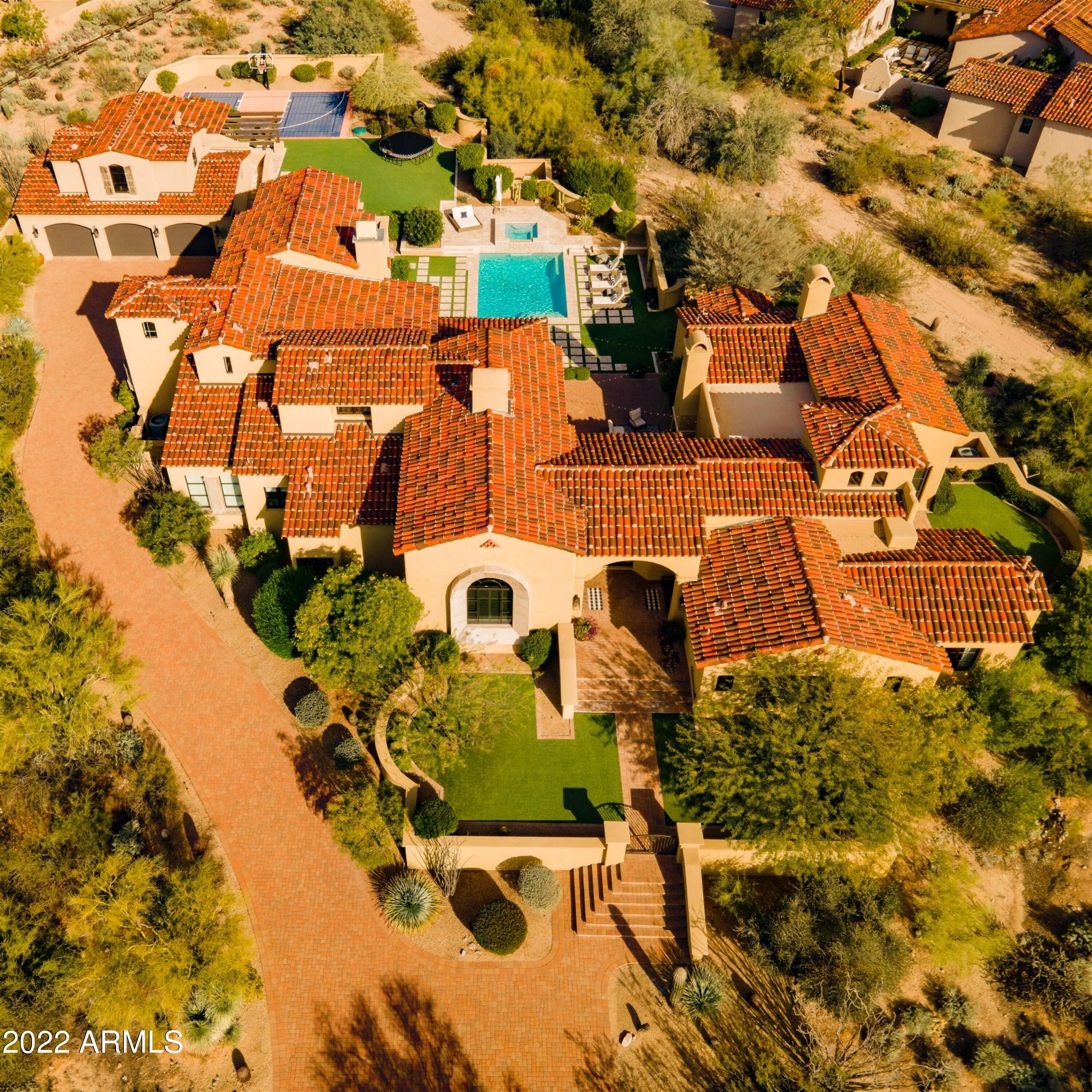 Desert Oasis nestled peacefully in the guard gated DC Ranch. When approaching this property one will notice it's timeless architecture. Enter through the home and immediately be drawn to the views and resort style back yard. This gourmet kitchen features dual islands and is appointed with a Wolf range and Sub-zero fridge by freezer. On this property you will find there are six bedrooms with on-suite baths including the 1st level Owner's suite with a sitting area and a private patio. Also in this home is a formal living and dining, an office, two family rooms and a flex space for an office/ craft space or playroom.  Accompanying the home is 5 well appointed garage spaces with the three car detached being climate controlled. Come enjoy