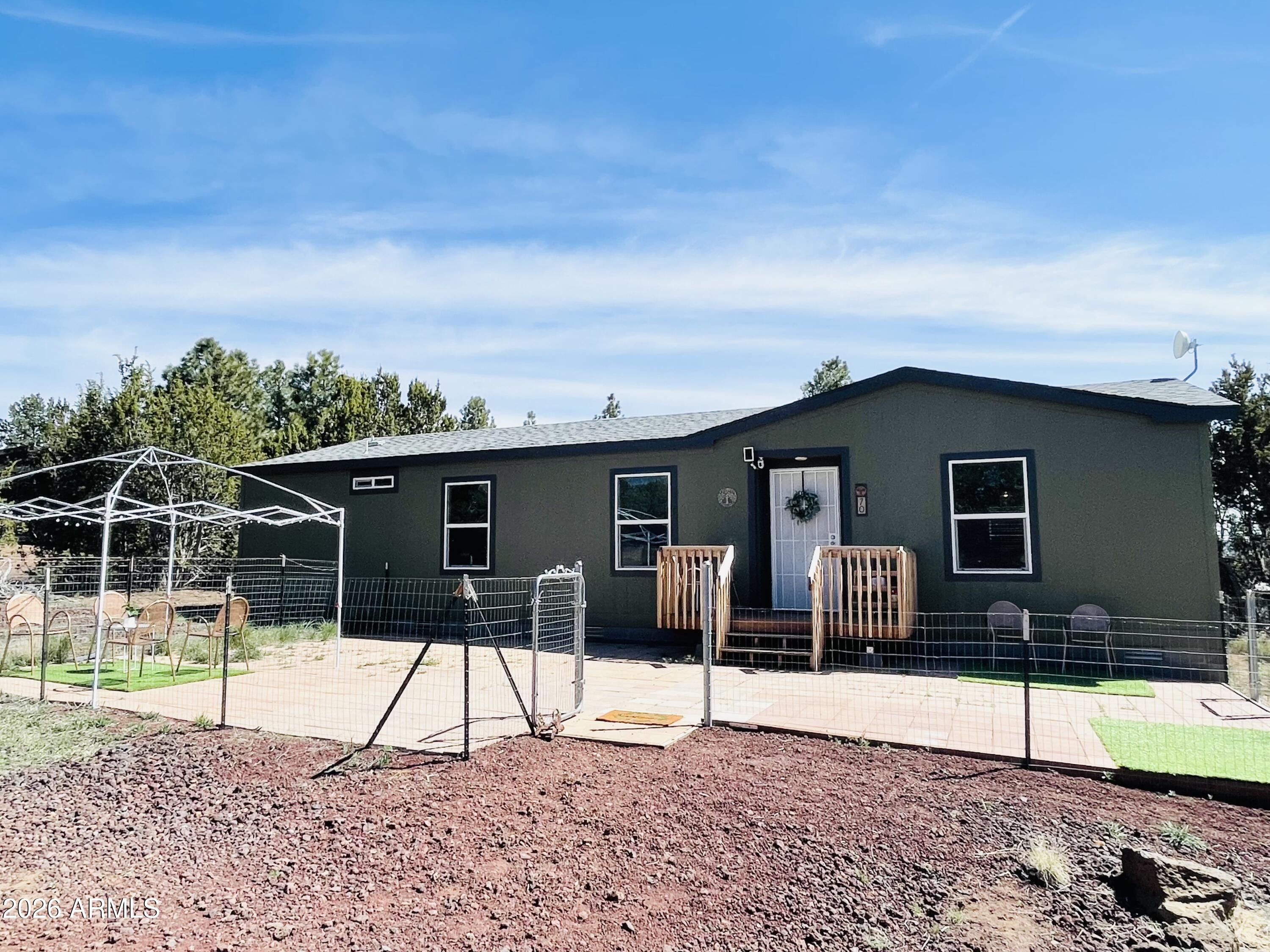 Welcome home to your sanctuary in the mountain pines. This airy and open 3-bedroom, 2-bathroom home has high ceilings and lovely natural light throughout. Easy living on all one level, the home is settled on 1.03 acre of forested land with mature ponderosa pines. Updates and improvements include 960 square feet of fenced front patio yard, a pretty 10 x 5 Trex front sitting porch, back landscaped sitting area with solar lighting, and a fire pit providing outdoor living space for your enjoyment. Interior includes  newer wood-look luxury vinyl blinds throughout, updated dining room light fixture, and updated kitchen with new stainless steel appliances and new gooseneck faucet, as well as newer GE washer and dryer in the dedicated laundry room. Exterior home and shed freshly painted, all under -home ductwork professionally updated with improved materials. Pride of ownership visible in every space with one owner for the duration; this home has been loved and cared for. You enter this welcoming home into a Great Room style open-concept space which flows into the well-designed functional kitchen. An inviting hallway with high ceilings leads you to the bedrooms and bathrooms. The main bedroom is spacious and flooded with light, complete with two separate walk-in closets, and a gorgeous en-suite main bathroom; with two separate sinks and walk-in shower, including a large linen closet with tons of storage. The second and third bedrooms are well-sized, bright, and comfortable. The roomy hallway bathroom includes tub/shower, and plenty of counter space and cabinet storage. Property conveys a Graceland 8 x 12 weather-tight storage shed with a vaulted roof and loft storage area to meet your storage needs. Whether you're relaxing and watching the sunset from front patio sitting area, or enjoying the fire pit out back, this is mountain living at its finest-all just 45 minutes from the Grand Canyon! The town of Historic Williams just 10 mins drive provides all the Amenities and Fun  throughout the year!  Bring your toys! No HOA! Beautiful peaceful area! Wonderful move in ready home!