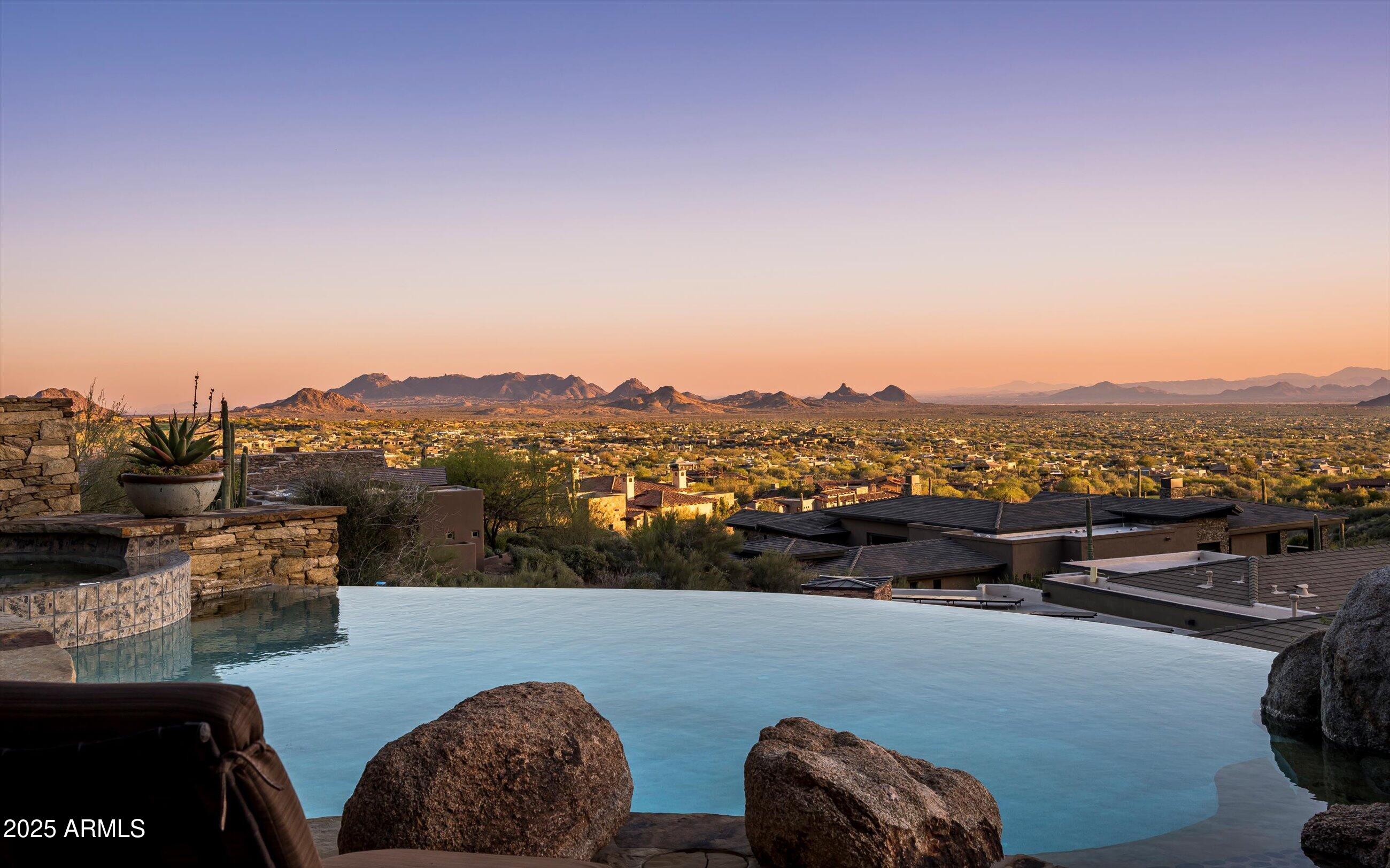 Golf membership available!  Experience timeless desert living in this stunning Lee Hutchison-designed masterpiece, perfectly positioned to capture sweeping down-valley views, glowing sunsets, and twinkling city lights.  Superior craftsmanship with natural stone and wood beams, this 4-bedroom, 4 bath & 2 1/2 baths estate blends design with elegance and modern comfort. Featuring a chef's kitchen with premium appliances and custom cabinetry, flowing seamlessly into the great room with exposed beams, artisan details, and expansive glass walls.  The home offers two dedicated offices, detached guest casita, and flex room.  Designed for Arizona's iconic indoor-outdoor lifestyle, the home offers 180-degree covered patios, an outdoor fireplace lounge, built-in BBQ, and lush desert landscaping. Offered furnished with some exceptions.