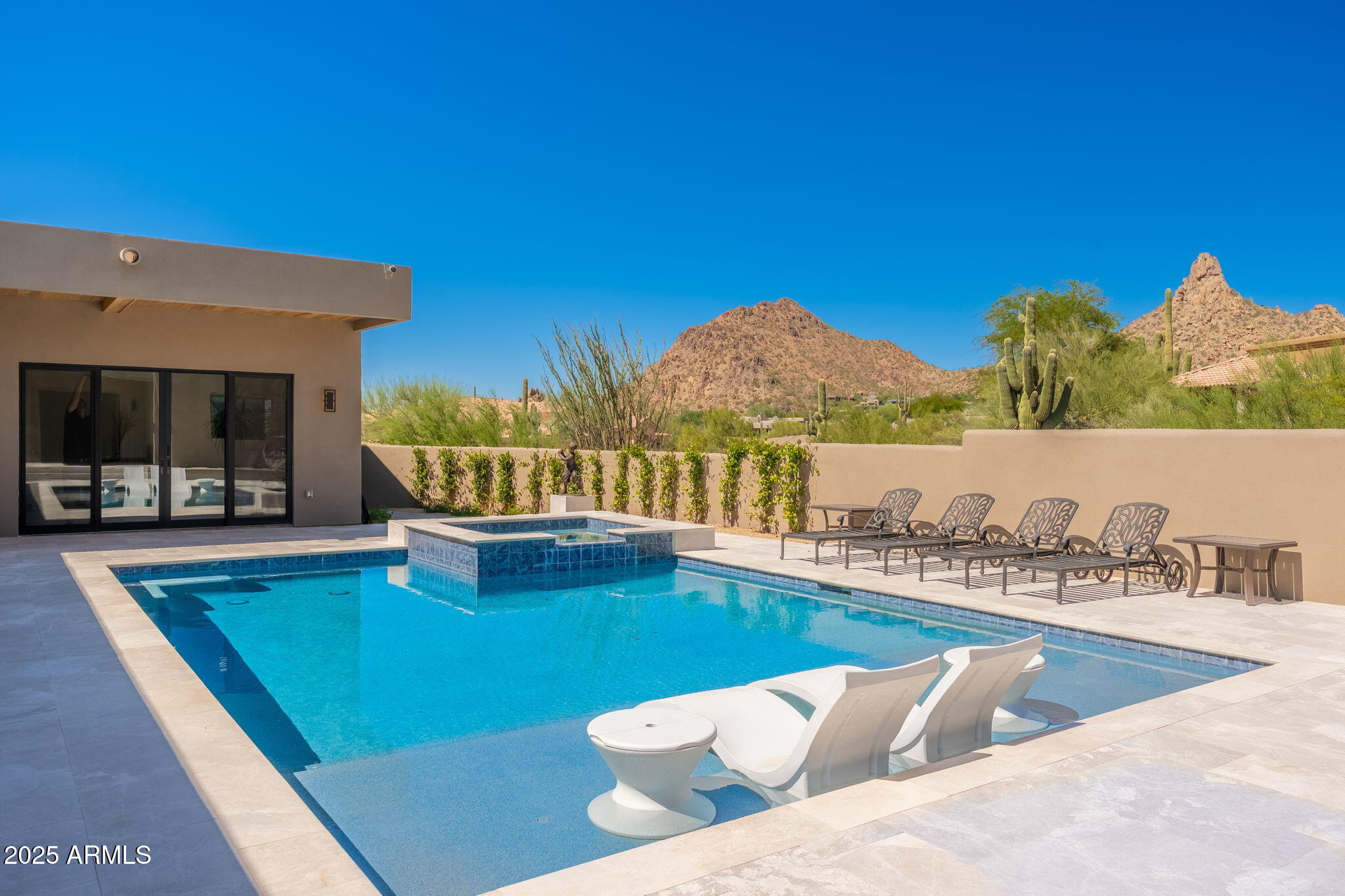 This newly constructed home combines Southwestern contemporary design, high-end finishes, smart home automation, with beautiful desert landscaping, panoramic mountain and city light views within the upscale gated community of Eagles Glen. Situated on nearly an acre, the property welcomes you with a grand artisan paver driveway, modern steel door and contemporary adobe design. 

This thoughtfully redesigned single-level split floor plan home, with detached casita offers open concept living, an abundance of natural light, and designer finishes throughout; including European hardwood floors, level-5 smooth drywall finishes, 8' interior doors, and a striking modern linear fireplace. The chef's kitchen is beautifully appointed, featuring sleek custom cabinetry, granite waterfall island, granite countertops, tile backsplash, custom wood panel Monogram appliances, wine fridge, beverage drawers, and an oversized walk-in pantry. 

A modern sliding glass door gently frames the Pinnacle Peak mountain range, seamlessly connecting the indoor-outdoor living spaces. Entertain family, friends and neighboring guests on the large covered patio, featuring a designer wood panel ceiling equipped with MistAmerica cooling system, surround sound speakers, outdoor Smart TV, built-in BBQ and outdoor kitchen; all while overlooking the newly constructed sparkling pool and spa, linear gas fire table, artificial grass, and desert by design landscaping.

The primary suite is a luxurious sanctuary, featuring dual vanities, a soaker tub, oversized walk-in multi-faucet shower, heated floors, granite countertops, and two spacious walk-in closets. Three additional en-suite bedrooms, plus a powder room and laundry room, complete the main residence. A detached guest house casita is completely self-sufficient, with a full kitchen, living room, and en-suite bedroom, providing privacy for guests or multi-generational living. Notable updates include a Savant smart home system, new HVAC systems, tankless hot water heaters, solar air-conditioned storage space, and epoxy garage flooring.

Located near Troon Golf and Country Club, The Four Seasons Resort, and scenic hiking trails including Pinnacle Peak, Tom's Thumb, and the McDowell Sonoran Preserve Gateway Trail. Just a short drive to upscale dining, shopping, and entertainment at Market Street, Kierland Commons, and Scottsdale Quarter, as well as WestWorld, TPC Scottsdale, Salt River Fields, and the world-renowned Mayo Clinic, with convenient access to the Loop 101 and 51 freeways for seamless travel throughout Scottsdale and Phoenix.