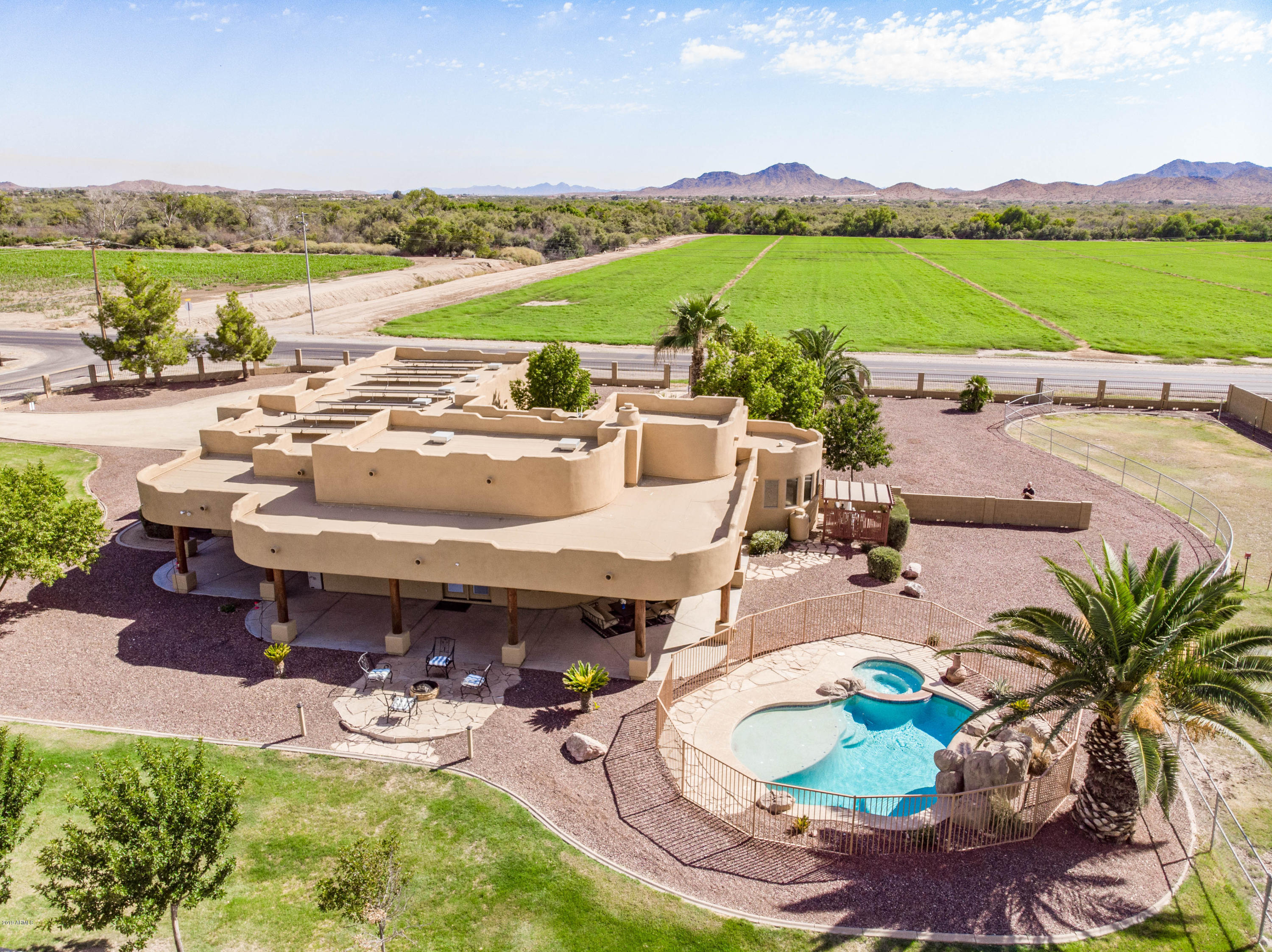 Luxury Ranch style living on 1+ acre flood irrigated horse property with mountain views.  SOLAR OWNED OUTRIGHT.  Fully fenced with electric gated entry.  Resort style backyard features heated pool /spa, expansive wraparound patio, fire pit. Horse facitlity includes stall and turn out pasture. Southwest-inspired interior with open great room, 12'/10' ceilings, viga beams, and travertine flooring. Chef's kitchen offers granite counters, large island, double ovens & stainless appliances. Spacious Primary wing offers oversized closet, walk-in shower, a jetted tub & dual vanities.  The extended 3-car garage is 28' deep. Numerous upgrades throughout.  Enjoy the freedom to live, work & play with space for horses, toys & more.