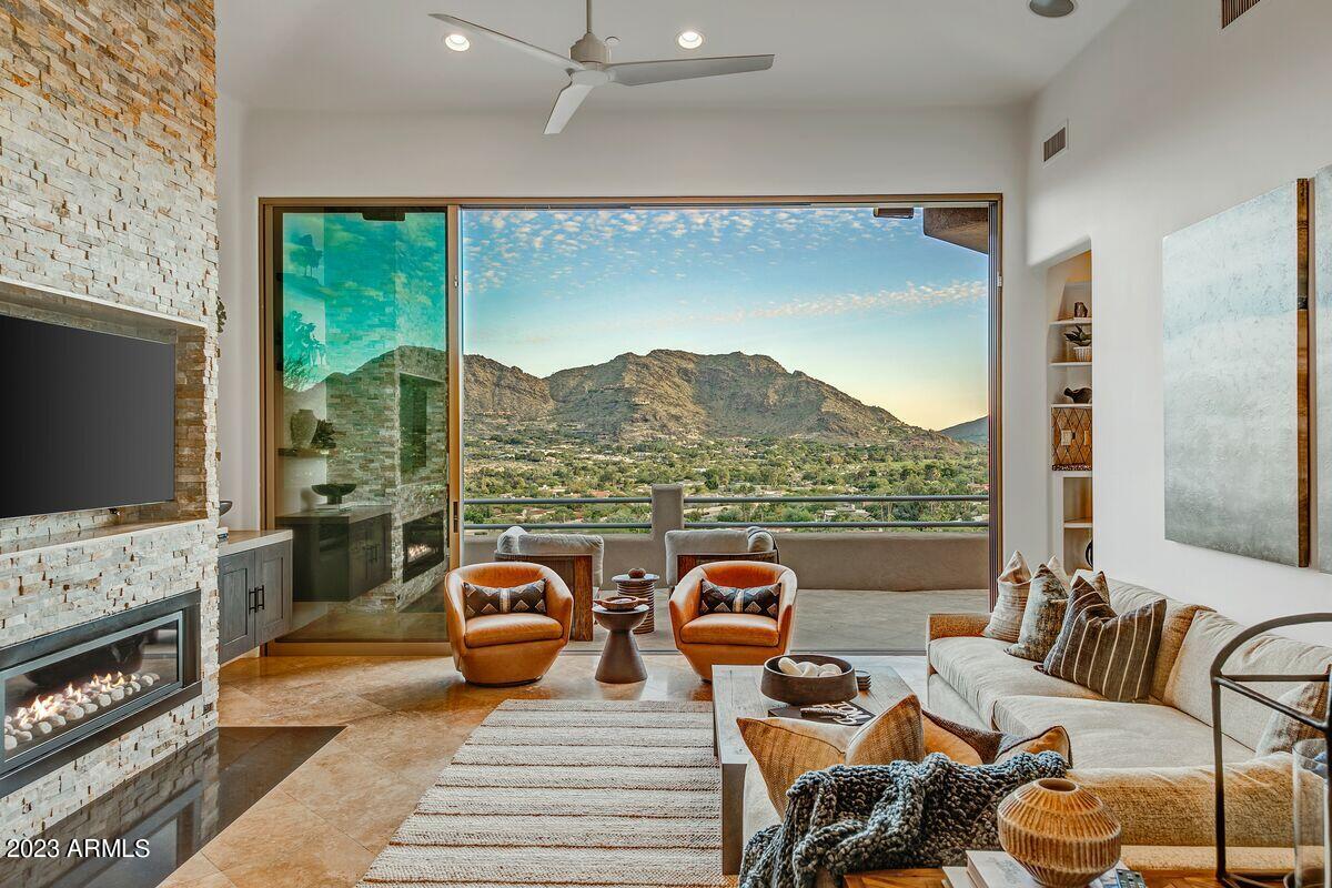 The best Camelback Mountain view house on the market! Boasting just under 4000sf, this home features 3 bedrooms and 3.5 bathrooms, offering unparalleled views of Mummy, McDowell, and Camelback Mountains from every room. Step onto the expansive wraparound decks, accessible from the master bedroom, living room, and kitchen. Luxury abounds with top-tier appliances, a refreshing negative edge pool, inviting spa, and charming guest quarters that create an idyllic living experience. The living room, kitchen and master bath have been recently updated to embrace a contemporary ambiance. Floor-to-ceiling windows serve as your gateway to daily inspiration, while the meticulously landscaped hillside setting envelops the home in natural allure. Complete with a 3-car garage and ample storage.