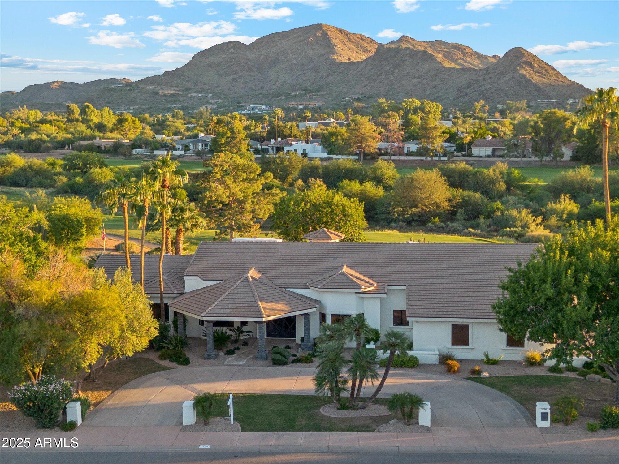The views and the location you're looking for are right here.  Golf Course, Mummy Mountain & Phoenix Preserve views in Paradise Valley! 
 A 2018 extensive renovation brought new life to the interiors, blending contemporary style and warm sophistication. Enter the home through its grand steel & glass entry doors and let the spectacular mountain and golf course views welcome you home. Soaring vaulted ceilings with striking wood beams offer dramatic ambience amid the feature stone wall, highlighting a contemporary gas fireplace alongside spectacular views. Open 12' stacking glass doors and create that indoor-outdoor lifestyle stepping out to the beautiful backyard filled with mature trees, lush landscaping, and a stunning saguaro cactus overlooking Mummy Mountain, the Phoenix Preserves and the renowned Camelback Golf Course. A chef's kitchen features a large center island, a large kitchen sink, vegetable sink, Thermador appliances, a 6-burner gas range, a spacious eat in breakfast room, more built-in cabinetry, a beverage refrigerator and more splendid views. The primary suite is a private sanctuary in this split floorplan home, offering a 10-foot tray ceiling, gas fireplace, spectacular mountain and golf course views, and an elegant bathroom with dual vanities, a makeup vanity, separate tub, marble shower, private water-closet and a large walk-in closet! 

The expansive south facing covered patio, complete with mister system, automated shade screens, wall- mounted TV truly show off the home's entertaining setting all while showcasing its breathtaking mountain and serene golf course views.  
Refined, updated, and designed for the way you want to live, this home is truly a rare opportunity to own one of Paradise Valley's finest homes.