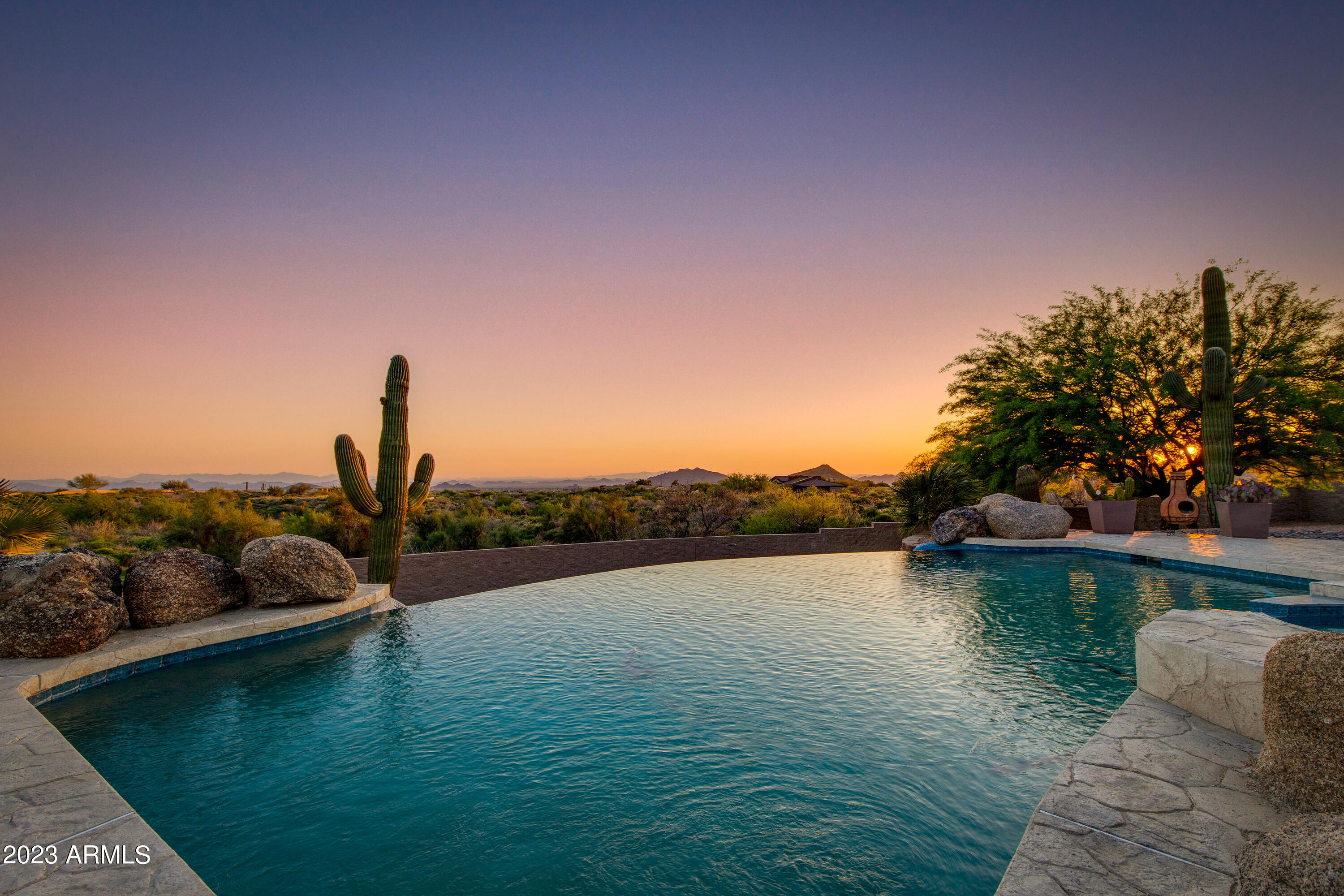 Indulge in the rare opportunity to own 5+ ACRES in North Scottsdale's EXCLUSIVE Quail Ridge gated community. Elevated at 3400 feet, enjoy stunning panoramic views of mountains and city lights from this hillside sanctuary. Beamed vaulted ceilings, three en-suite guest bedrooms, and a grand primary retreat with a separate sitting area, kiva fireplace, custom dual walk-in closets, and private patio adorn this masterpiece. Indulge in the massive chef's kitchen featuring a dual Wolf range, Sub-Zero, two dishwashers, custom cabinetry, and walk-in pantry. Lounge by the negative-edge pool and covered patio while taking in the best views in the valley. This home offers unparalleled private luxury!