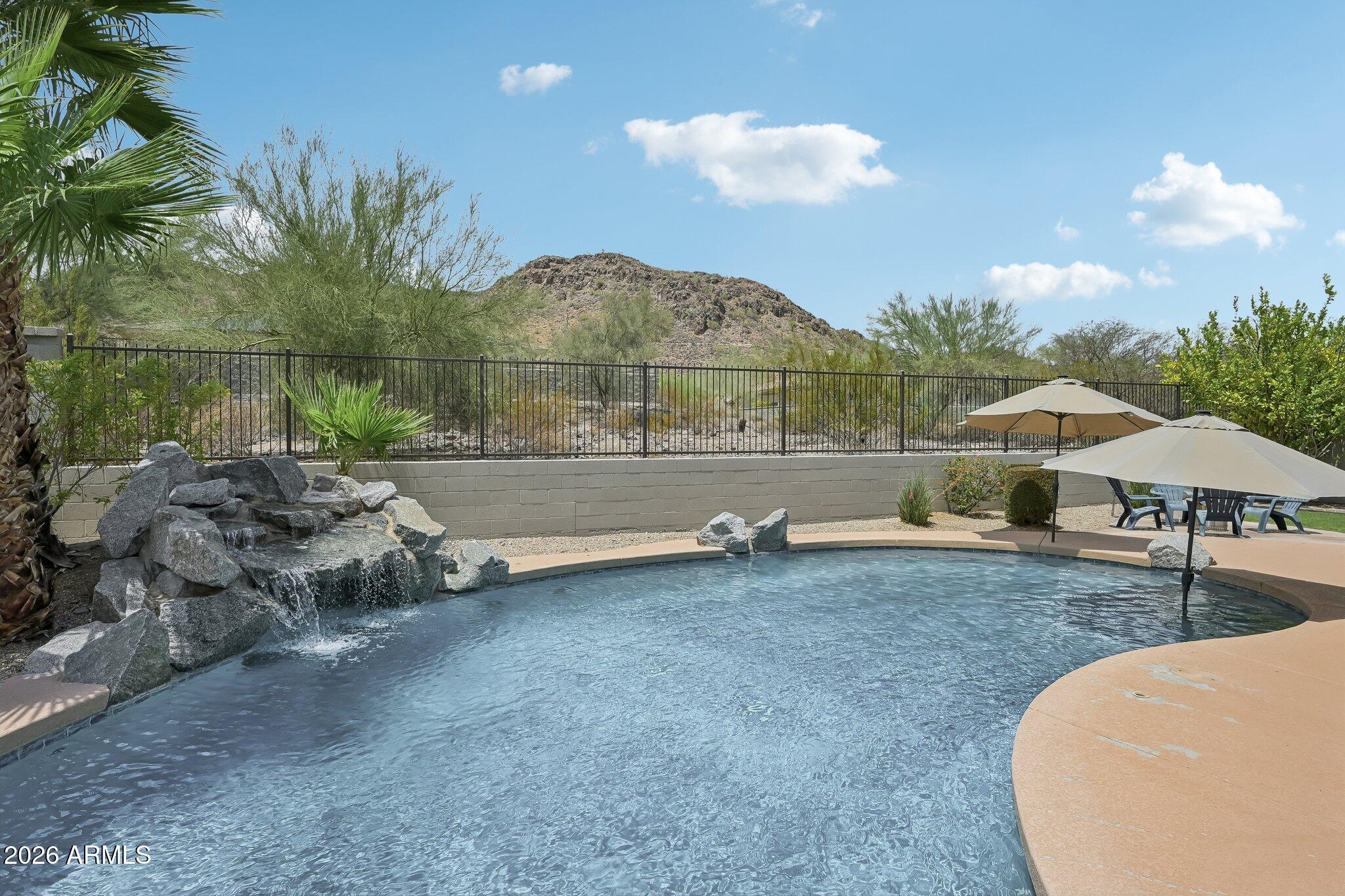 Arizona living at its best! Updated home located on a premium view lot in Westwing Mountain community.  Breathtaking mountain views from your backyard featuring a sparkling play pool, lush grassy area, & covered patio! Perfect for entertaining, relaxing, or enjoying spectacular sunsets. 5 bedrooms, 4.5 bathrooms, a 3-car garage, & oversized upstairs bonus room ideal for a media room, game room, fitness space, or second living area! Main-floor bedroom with a walk-in closet & next to full bath is perfect for guests, multigenerational living, or home office. Updated gourmet kitchen with quartz countertops, center island with breakfast bar, gas cooktop, walk-in butler's pantry all open to family room! 2 HVAC units newer! Assumable VA  loan! Parks with tennis, volleyball & more! Hiking trails! Exterior paint 2026, water softener replaced 2024 and hot water heater replaced 2021. Primary bath updated in 2025 and kitchen updated 2026. Home is refreshed and ready for new owner!