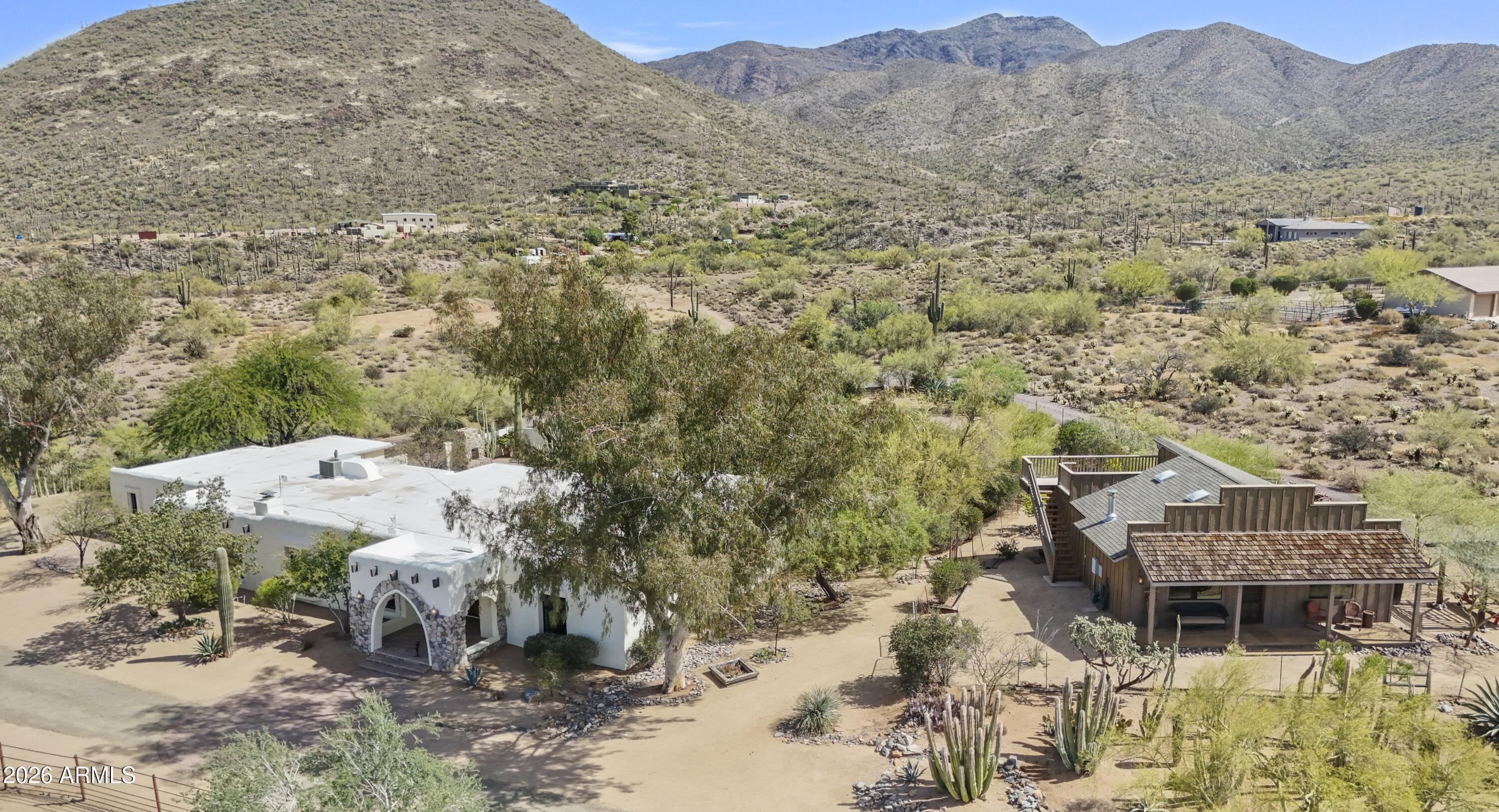 Priced under appraisal, Big Ranch Wannabe is for sale after 20+ years. This is the Wild West, where open skies and mountain views stretch across nearly 5 private acres. This gated homestead has 3 beds, 2.5 baths, hickory wood and Saltillo floors, beamed ceilings and rugged Western charm. By the 3195 sf main home, the 978 sf saloon stands proud with its boomtown façade and wide front porch. Complete with open living/kitchen for entertaining, and 2 beds and a bath for folks who bunk in. The M&D barn has 3 large stalls and 2 100' x 70' turnouts. With a 3-car garage, extra garage and storage building, there's room for all your gear. Tons of room for an arena too. Take a cowboy soak in the backyard pool off the covered porch. Close to town and paved all the way, yet very private.