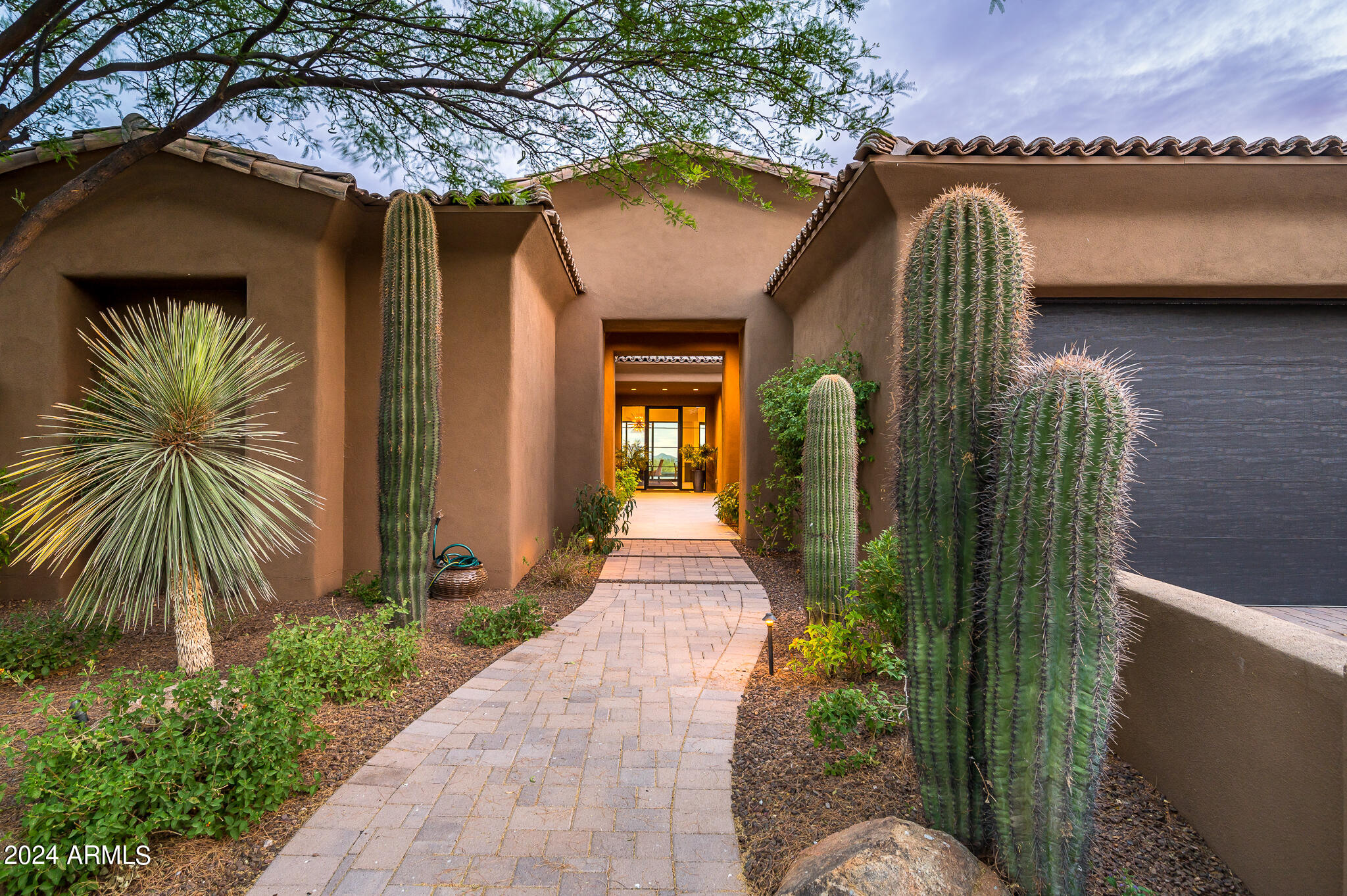 Very private yet open space feel with fantastic city light, sunset and mountain views.  Step inside this outstanding all ONE LEVEL contemporary home and experience Arizona living at its finest.
The warmth of the courtyard with linear fireplace sets the stage for the ultimate indoor/outdoor living experience. Once inside, a captivating see-through wine structure and main living areas continue through glass telescoping wall  to the outdoors combining the inside and outside into one entertaining experience. 
The two inviting gathering areas with full size bar are open to the gourmet kitchen featuring Wolf and Sub Zero appliances, a large island and hidden walk-in pantry.  The dining / morning room is sure to please with its opening up to the front courtyard.
Outdoors features negative edge pool, spa, barbecue, conversation area with fireplace, lounging and dining patios areas to relax and enjoy with family and friends.
Conveniently located mid-mountain and within walking distance to the Sonoran Fitness Club.