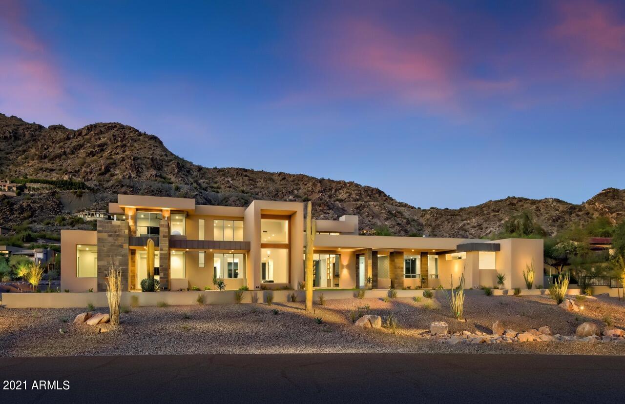 Situated at the foot of Mummy Mountain with spectacular views of Camelback Mountain, this grand modern estate was completed in 2015 by BedBrock Developers, Paradise Valley's premier luxury custom home builder. The crisp lines of this elevated design flow seamlessly throughout the 6200+ square feet home by the well-known Western architect CP Drewett. The spacious home is designed in a neutral color palette with ranging décor from light and bright to boldly dark accents which draw focus perfectly around the many beautiful features. The architecture is designed to thrill and delight the most discerning of refined senses with upgraded top-of-the-line finishes. Chef grade gourmet kitchen is well equipped with advanced state-of-the-art stainless steel appliances including a Wolf 6 burner gas range with 2 ovens, water spigot, and stainless steel wood. The edgy flair of the back splash compliments the counter tops impeccably.  A wine display is perfectly situated in the great room showcasing the attention to detail and convenience of design exclusively reserved for luxurious and affluent high-end estates. The inspired master suite includes a sitting area and a fireplace leading to the master bath. Symmetry and balance of design grace the master bathroom presenting all the amenities including glass enclosed shower, vanity with double sinks, bathtub, and separate toilet room. This home features the ideal balance of indoor and outdoor living with folding exterior glass doors that pocket into the wall offering full views of Camelback Mountain on one side and Mummy Mountain on the other side of the great room. The guest casita with its separate entrance is the complete private oasis for your guests. Patio with outdoor kitchen is perfect for entertaining, relaxing, and enjoying the mountain views. Impeccably manicured grounds feature a fireplace, pool, and spa.  This highly desirable modern estate is unusually exceptional and likely to be quickly acquired.
