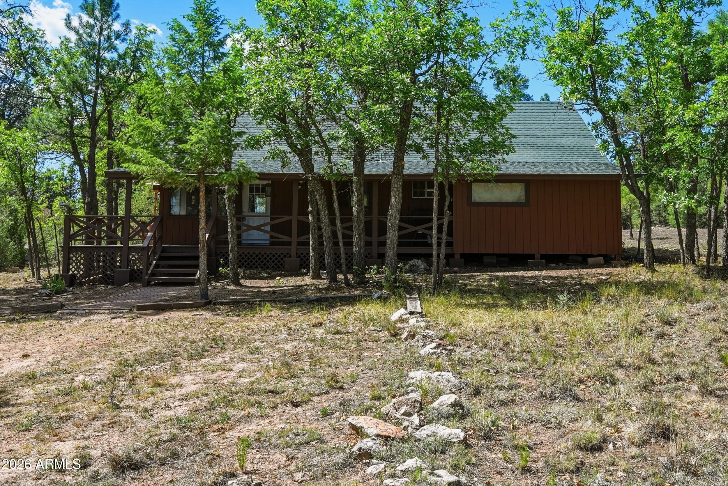 Looking for your cozy cabin that backs National forest, walk out your driveway to the forest.  Cute 3 bdrm 1 bath cabin with updates.  New flooring throughout, paint inside and out is new, kitchen cabinets just installed and new bathroom vanity.  Ready to use and escape the heat.  Beautiful lot with plenty of room for RV parking, horses or to build a garage or out building. This would make a great weekend home, full time or even a VRBO (Non-HOA). Come buy your little slice of Heaven.