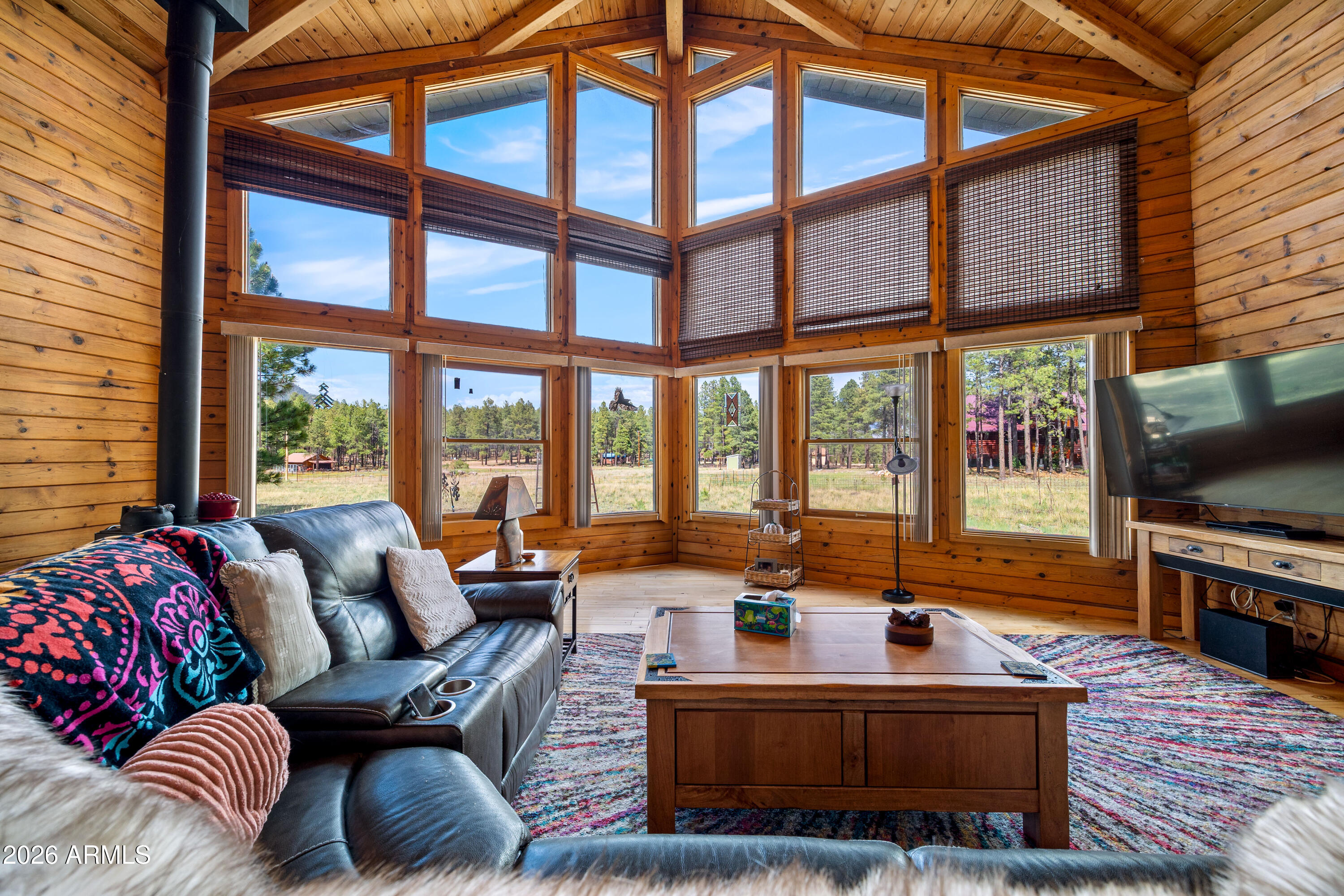 Mountain Lodge Style Home on 2.21 Acres in Alpine, Arizona

Nestled beneath towering ponderosa pines on a beautiful 2.21-acre parcel, this inviting 2,308 sq. ft. mountain home offers the warmth and character of true cabin living. Featuring 2 bedrooms, 2 bathrooms, and an abundance of rich wood finishes throughout, this property is ideal as a full-time residence, seasonal getaway, or peaceful mountain retreat. The spacious great room showcases dramatic vaulted tongue-and-groove ceilings, an impressive wall of windows framing the surrounding forest, and a cozy wood-burning stove that creates the perfect gathering place on cool mountain evenings. Solid wood flooring extends through most of the home, enhancing its timeless mountain charm and rustic elegance. The adjoining kitchen offers generous oak cabinetry, stainless steel appliances, a center island with breakfast seating, and flows seamlessly into the dining area for easy entertaining.

Both bedrooms are generously sized, including an expansive upper-level retreat with vaulted ceilings and ample room for a sitting area. A dedicated office/bonus room, warmed by an efficient pellet stove, provides flexible space for working from home, hobbies, or additional guest accommodations.

Step outside and enjoy the tranquility of Alpine overlooking the wooded setting. The level 2.21-acre property offers room to roam while maintaining a private mountain atmosphere.

Adding tremendous value is the impressive 2-car tandem garage, complete with its own bathroom, unfinished loft with future potential, an attached covered patio, a finished bonus room used for extra storage, and covered wood storage--ideal for hobbies, workshop space, recreational equipment, or additional storage.

Surrounded by mature ponderosa pines in Arizona's scenic White Mountains, this property offers the peaceful lifestyle buyers seek while providing the opportunity to add their own personal touches.

Property is being sold AS IS, presenting an excellent opportunity to own a spacious mountain home with exceptional potential in one of Alpine's most desirable settings.