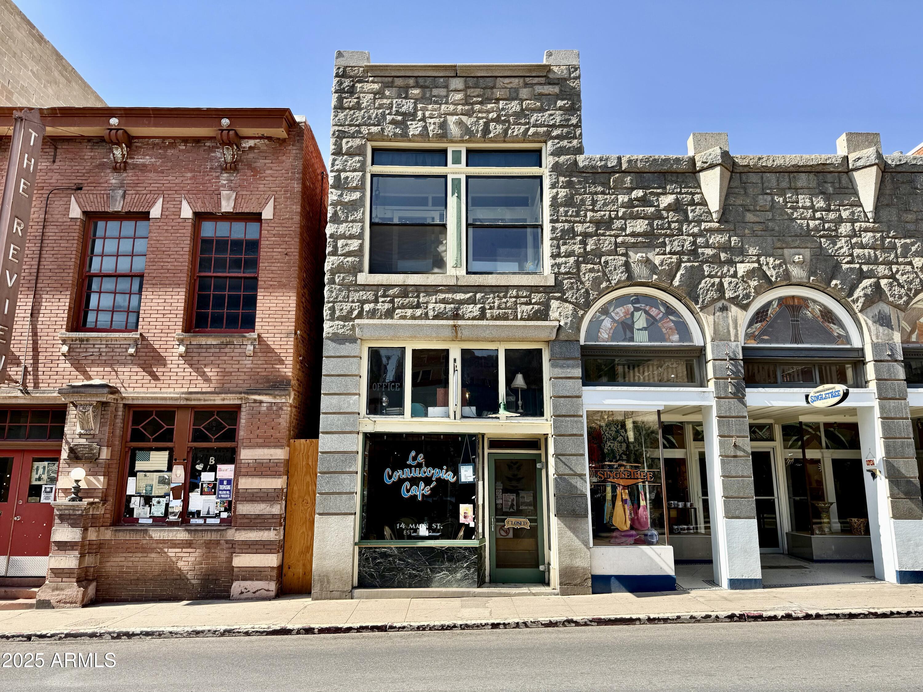 **INCOME PRODUCING PROPERTY. Restaurant is LEASED.  BUILDING FOR SALE!** Prime Commercial Opportunity with Commercial Tenant AND Airbnb or Long-term Residential Tenant Potential.  Nestled in the heart of the Bisbee Historic District, 14 Main St is a great, affordable opportunity, to own a piece of Arizona's storied past while capitalizing on its vibrant present. Built in 1902, this iconic building is steeped in the rich history of Bisbee, a once-thriving mining town now celebrated as one of Arizona's premier destinations for art, culture, and tourism. Surrounded by charming boutiques, eateries, and galleries, this property offers outstanding visibility and foot traffic in the heartbeat of Old Bisbee. The 809 sq ft ground floor, at street level, had been set up featuring a restaurant space with seating room for 28+.  Original penny tile flooring can still be seen.  An added bonus to this space is the huge storage cellar with time worn wooden timber stairs - wine cellar anyone?  Complete with a commercial kitchen, this space is ideal for someone's vision of a new café, wine tasting room, wine bar, or retail venture.  Primed and ready to serve Bisbee's steady stream of locals and tourists. The flexible C-1 zoning supports a variety of uses, including restaurants, retail, or specialty services.

Upstairs, a beautifully appointed 809 sq ft one-bedroom studio/loft operates as a successful Airbnb, capitalizing on Bisbee's growing tourism market.  The 1-bedroom walkup loft apartment has hip New York vibes, featuring original wood floors, exposed brick, and soaring ceilings and skylights. And the views are unmatched. This gorgeous loft is a favorite on Airbnb!  With its proximity to Main Street's attractions and the town's reputation as a top travel destination (named one of Travel Lemming's 50 Best Places to Travel in 2024), this loft is a proven income generator.

Constructed during Bisbee's mining boom, 14 Main St stands as a testament to the town's early 20th-century prosperity, when the Copper Queen Mine attracted dignitaries and investors. Its inclusion in the Bisbee Historic District underscores its cultural and architectural importance, offering a blend of nostalgia and opportunity for the discerning buyer.

Situated in the heart of Old Bisbee, 14 Main St benefits from the town's vibrant mix of Victorian charm and modern allure, drawing birders, hikers, wine enthusiasts, and art lovers year-round. The surrounding Mule Mountains and historic landmarks enhance its appeal.  With Bisbee's established visitor base and growing prominence, this property offers an exciting opportunity to own a landmark building with both commercial and residential income potential. Whether you envision a bustling café, a chic wine bar, or a curated retail space, 14 Main St is poised for success.  Seller is willing to consider Owner-Carry Financing with acceptable offer.  Own a piece of Bisbee's legacy while shaping its future.
*Restaurant space HAS BEEN LEASED.  COMING SOON - SKYHAVEN WINE TASTING ROOM!!