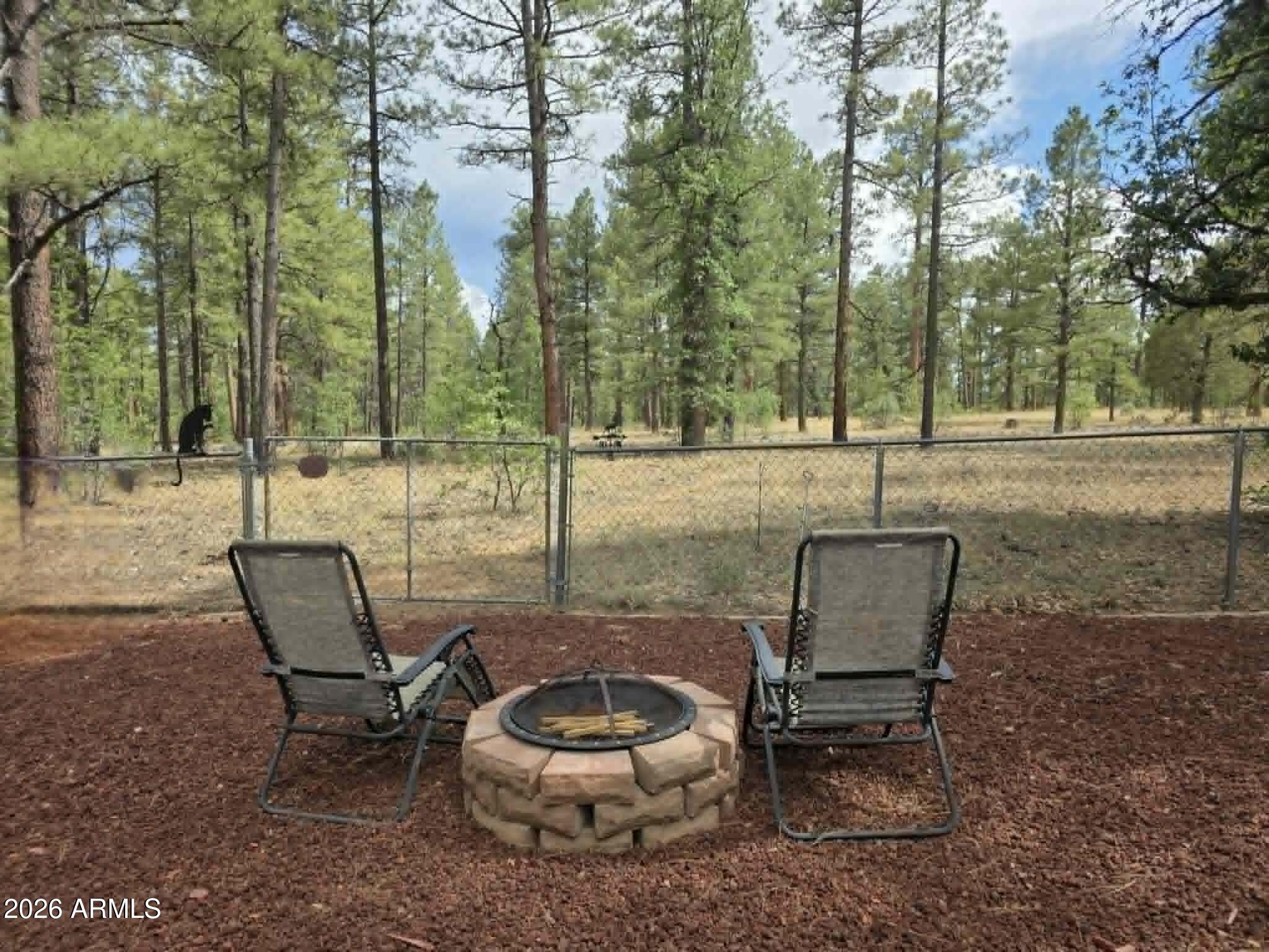 Imagine your own sound of the Whispering Pines and the clean scent.  Grab your favorite beverage and sit and just listen to the breezes blow through the pines.  Your home backs up to the USFS.  This home offers a sense of comfort, from the tasteful remodel that that owners have put forth down to the wood stove that will give you that relaxing cabin touch. The covered deck that greets you has just been freshly redone.  Step in to the open floorplan that keeps you in the conversation with your family and friends. Your pane kitchen window overlooks the yard. Large utility room is more than just for laundry. The split floorplan gives privacy.  Outside you will see 16x26 outbuilding that has just been completely redone inside - Comes with Conley Pool Table, New wood stove and lots of additional features for Entertainment or for a space of your own.  New fencing in front of home.  Additional out buildings for storage.  A greenhouse just waiting to produce the things you love to grow. So much to see.  Nice touches throughout property.  Most furnishings will stay with property, ie...recliner, sectional couch (3mo old), end tables, dinner table, 2 beds, dresser, outdoor patio table, attached TV's Upgrades or Items that have been replaced - ie...new flooring (laminate) throughout home, painted walls inside home, New blinds in bedroom and kitchen. Outbuilding with pool table..ie..painted inside, new flooring, new wood stove, replaced windows, replaced lighting. Repaved back patio, large tree removed, landscaped yard with rock. new roof above laundry room.  Original roof approx 6yo. New front fencing, new front porch railing and deck also redid back porch area.  Replaced refrigerator, added security screen door to back.  Replaced light fixtures throughout home.  Shiplap on walls in nook area. Tankless water heater, insta hot water on demand, walls are all extra insulated with fur buildout. 10x12 Graceland Barn Style shed with loft area. 4x8 tool shed connected to home. Subdivision has community well-JW Water/Prescott. Security System does not convey.
