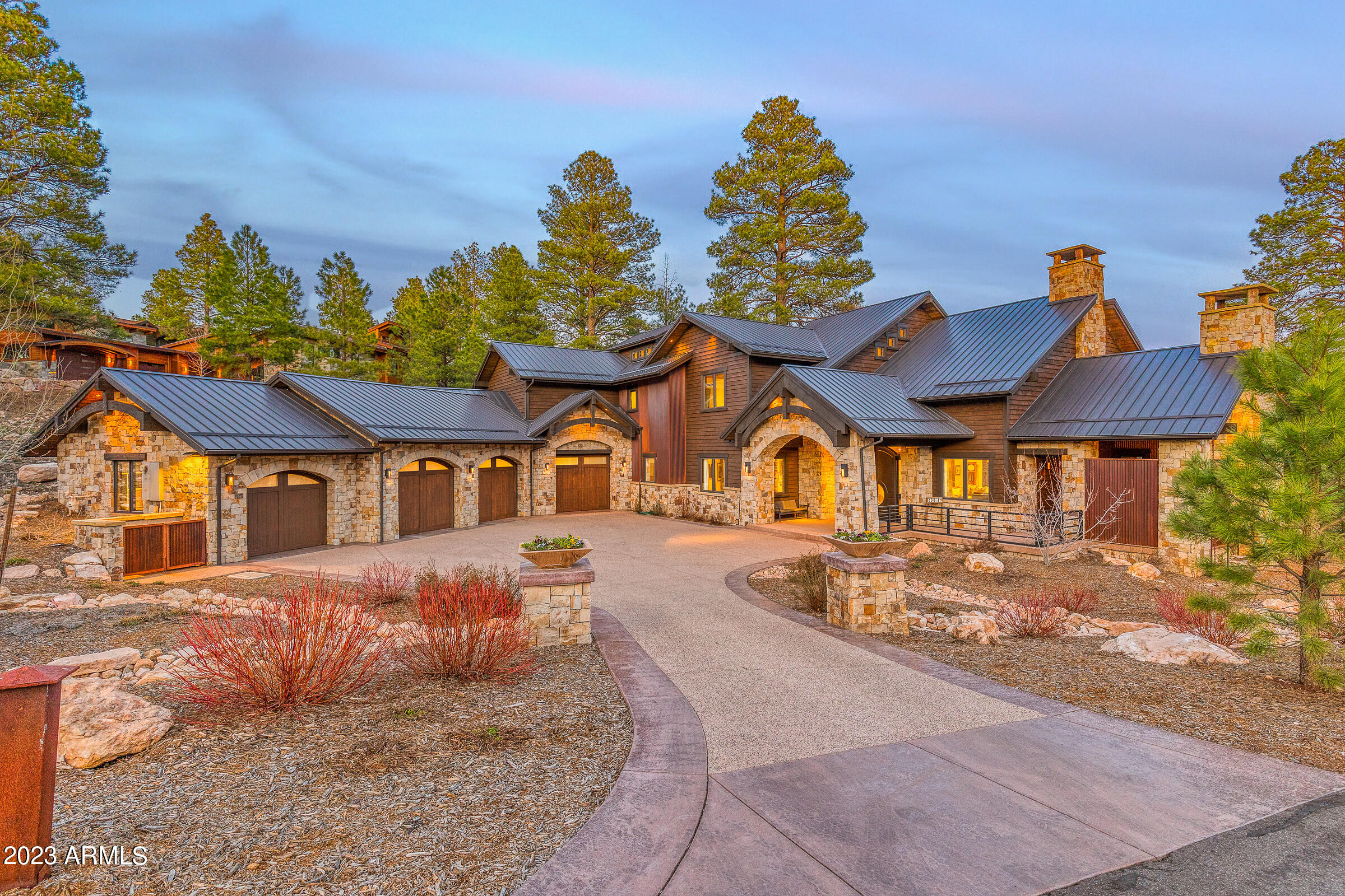 Lot 42 – This stunning mountain contemporary estate is located in the Pine Canyon golf community and is being offered turn-key, fully furnished. The property features 5 en-suite bedrooms, 6.5 bathrooms, and boasts a spacious 5,999 sqft of living space.  The 0.71 acre homesite provides plenty of outdoor space for recreation and relaxation, with breathtaking views of the par 3 #11 green and water.  This custom estate designed by Shapes and Forms Architecture and completed in 2017 by Harmony Builders is a truly impressive work of art.  The smart home technology, including a Control4 automation system, adds to the convenience and luxury of the estate. The 26-foot ceilings with exposed beams, lava grey hand distressed wood flooring, and Cambria stone countertops with a walnut butcher block slab create a warm and inviting atmosphere. The maple and walnut wood grain cabinets throughout the home provide ample storage and add to the home's overall aesthetic.  Along with a beautiful office space that is perfect for working from home.
The gourmet kitchen is equipped with a Wolf 6 burner gas range, Sub-zero built-in designer series refrigerator, Miele coffee system and microwave is perfect for the aspiring chef in your family.
The master suite is a true retreat, complete with a private balcony, stone gas fireplace, and sitting area. The master bath boasts floating dual vanities with quartz countertops, an oversized steam shower, and a jacuzzi soaking tub.
The indoor/outdoor bar is perfect for entertaining guests, with a Thermador wine refrigerator, draft tap, and refreshment cooler. The high-top bar seating over the tranquil water feature is a unique and beautiful feature that will be sure to impress.
The private side patio with an outdoor kitchen, BBQ grill, and wood-burning gas fireplace is perfect for enjoying the beautiful mountain views. The 10-seat theater room is perfect for movie nights with family and friends.
Finally, the 4-car heated garage with epoxy flooring, built-in cabinetry, dog wash station, and Tesla charger, as well as the heated driveway, provide the ultimate in convenience and luxury. This mountain contemporary estate truly has it all!