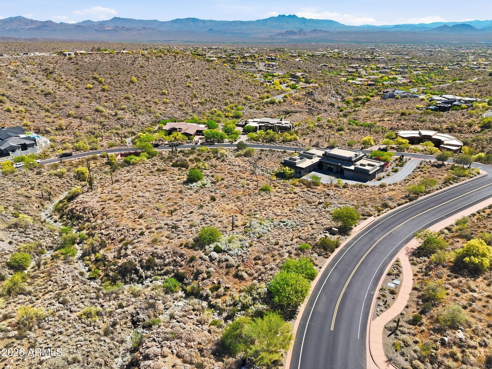 A phenomenal opportunity to create a truly bespoke hillside desert retreat within the prestigious, guard-gated Eagles Nest community. This expansive homesite captures breathtaking panoramic views of the surrounding Sonoran Desert, the iconic Four Peaks, and the renowned Fountain Hills Fountain. Set within this exclusive enclave of custom estates, Eagles Nest offers a rare blend of serenity and refinement, yet just minutes from world-class golf, scenic hiking trails, upscale shopping and dining, and the vibrant art and cultural experiences that define Fountain Hills living.
Included with the property are plans for a striking contemporary residence designed by the acclaimed PHX Architecture. Thoughtfully conceived to complement the natural landscape, the design features open-concept living spaces, dramatic floor-to-ceiling glass, and a seamless indoor-outdoor flow. Bring this vision to life with Weber Construction, renowned for their outstanding craftsmanship and meticulous attention to detail, or select your own builder to create a home that reflects your personal style and vision.

This is an invitation to build something truly opulent, intentional, and uniquely yours.