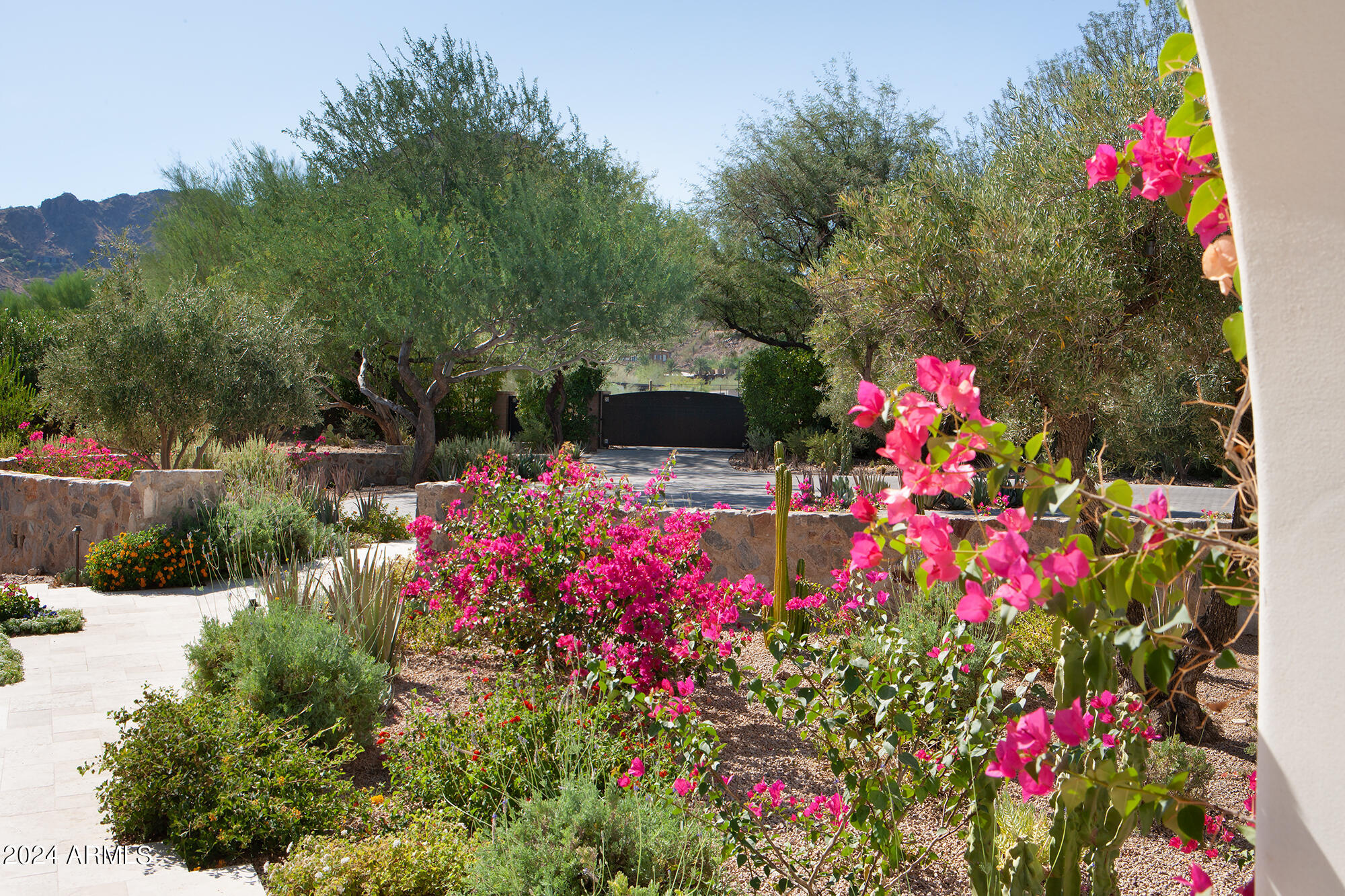 Exquisite desert oasis on Mummy Mtn.  A privately gated 3.34 ac Spanish Revival estate filled with quiet refinement, artistic vision, and state of the art technology.  One of the last remaining large, intact lots on the mountain. The views, the grounds, the ancient olive trees combine to create an awe inspiring tranquil retreat.  Completely updated/renovated in 2021-22 by Phx Architecture & Salcito Custom Builders, incl. solid walnut & limestone floors, Albertini steel windows, Caesarstone countertops, hand made Craftsman Court tile, antique stone fireplaces. Lutron & Savant integrated systems control audio, visual, lighting, HVAC.  Two kitchens, Main + Prep.  Fully built-out (1660sf) gym for any serious athlete + separate full GH.   5 Car A/C garages, motor court w/ entry & service gates Zillow users, please click on the "more" tab under Facts and Features to access the amazing virtual tour.