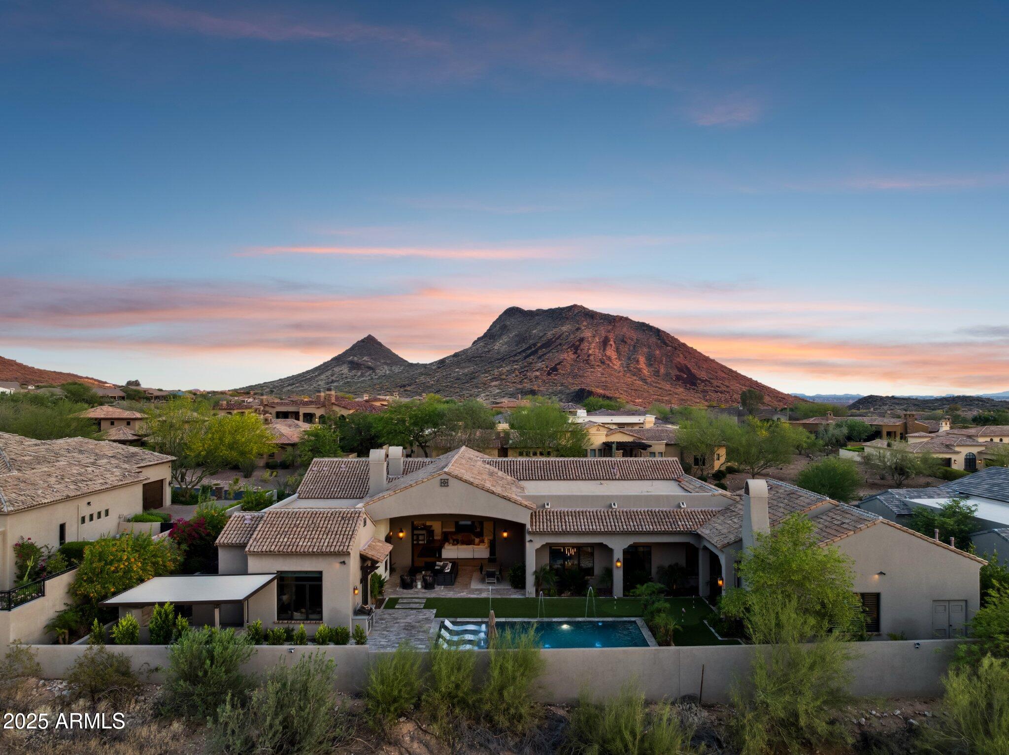 Discover a rare blend of refined craftsmanship, timeless design, and modern luxury in this exceptional Mark Steimer custom home, nestled within the prestigious gated community of Sierra Hills with only 32 homes. Recently reimagined as a desert retreat, the outdoor space also offers a full outdoor kitchen, putting green, newly paved pathways, mature fruit trees, and lush landscaping added in 2024.

Designed to capture the beauty of its surroundings, this home features automated sliding doors that frame unobstructed mountain views and create a seamless flow between indoor comfort and outdoor serenity. 

The expansive covered patio with a fireplace and soaring ceilings leads to a resort-style backyard complete with a heated pool featuring in-water chaises, fire and water features, built-in coolers, and a spa.

Perfect for entertaining or quiet evenings at home, the floor plan includes formal dining with a climate-controlled wine cellar and casual spaces with breathtaking views. The spacious split layout includes 5 bedrooms and 4.5 bathrooms, including a serene primary suite with a spa-style bath, double rainfall showers, and attached casita. Rich finishes like stained wood shutters, wood-stained doors, and ogee-edged countertops enrich every room. A five-car garage with EV charging, U-shaped driveway, and ample guest parking.

Tall ceilings with wood beams, corbel archways, crystal chandeliers, and limestone fireplaces showcase the home's exceptional detail. The show-stopping T-shaped island is wrapped in leathered granite, while surrounding quartz countertops and contemporary lighting elevate the kitchen's elegance and functionality.

Every inch of this home invites you to indulge in comfort, beauty, and peace, making it one of Sierra Hills' most coveted properties.

Whether you're relocating from out of state or seeking your next-level dream home, this residence offers a seamless transition into a beautifully curated lifestyle that values comfort, design, and tranquility